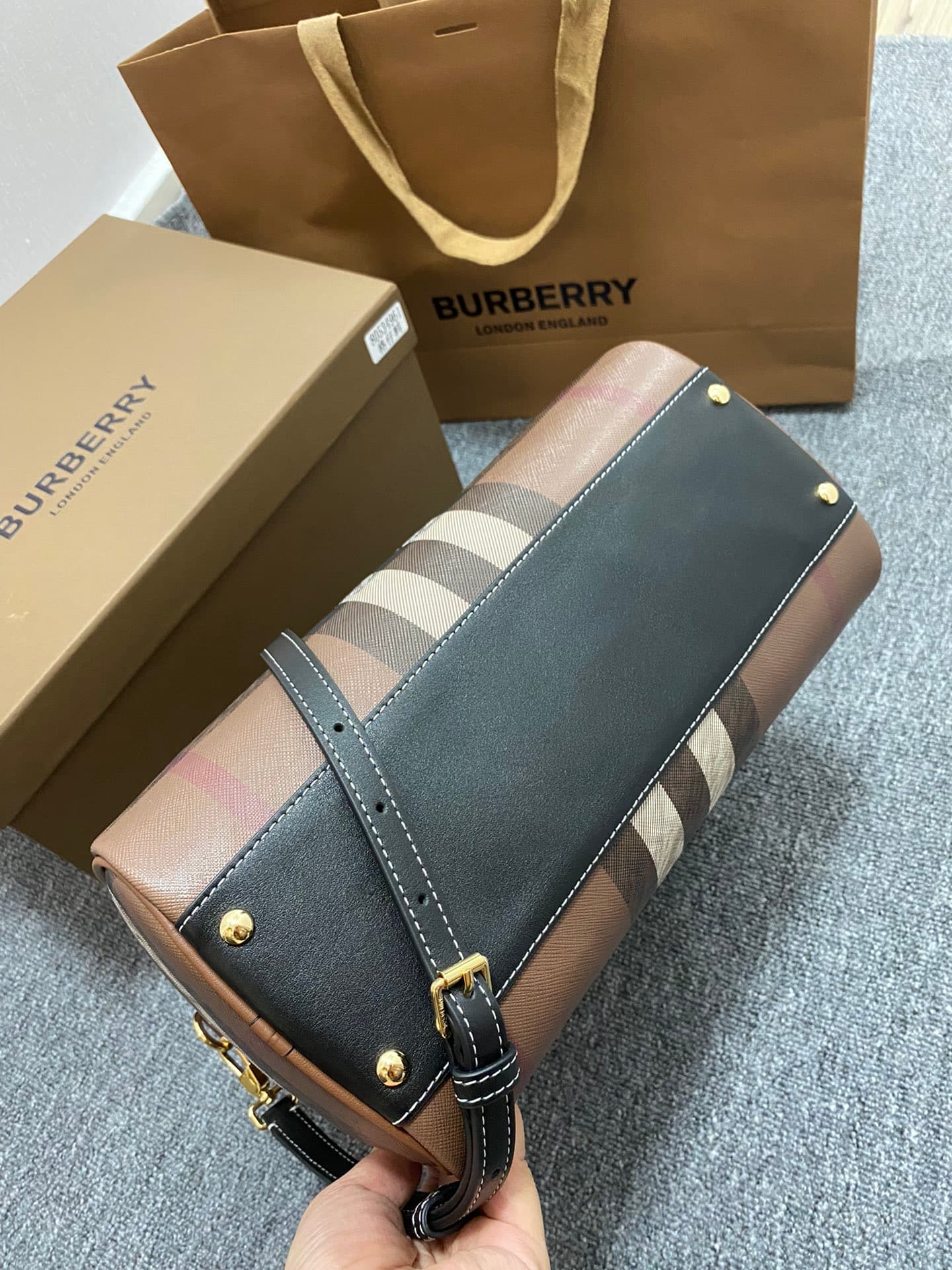 C68 The latest Italian-quality bowling bag from B brand is made of plaid material and leather with visible seams. It features a leather handle at the top, detachable and adjustable shoulder straps, zippers, as well as a leather-lined lock and luggage tag. — image 4