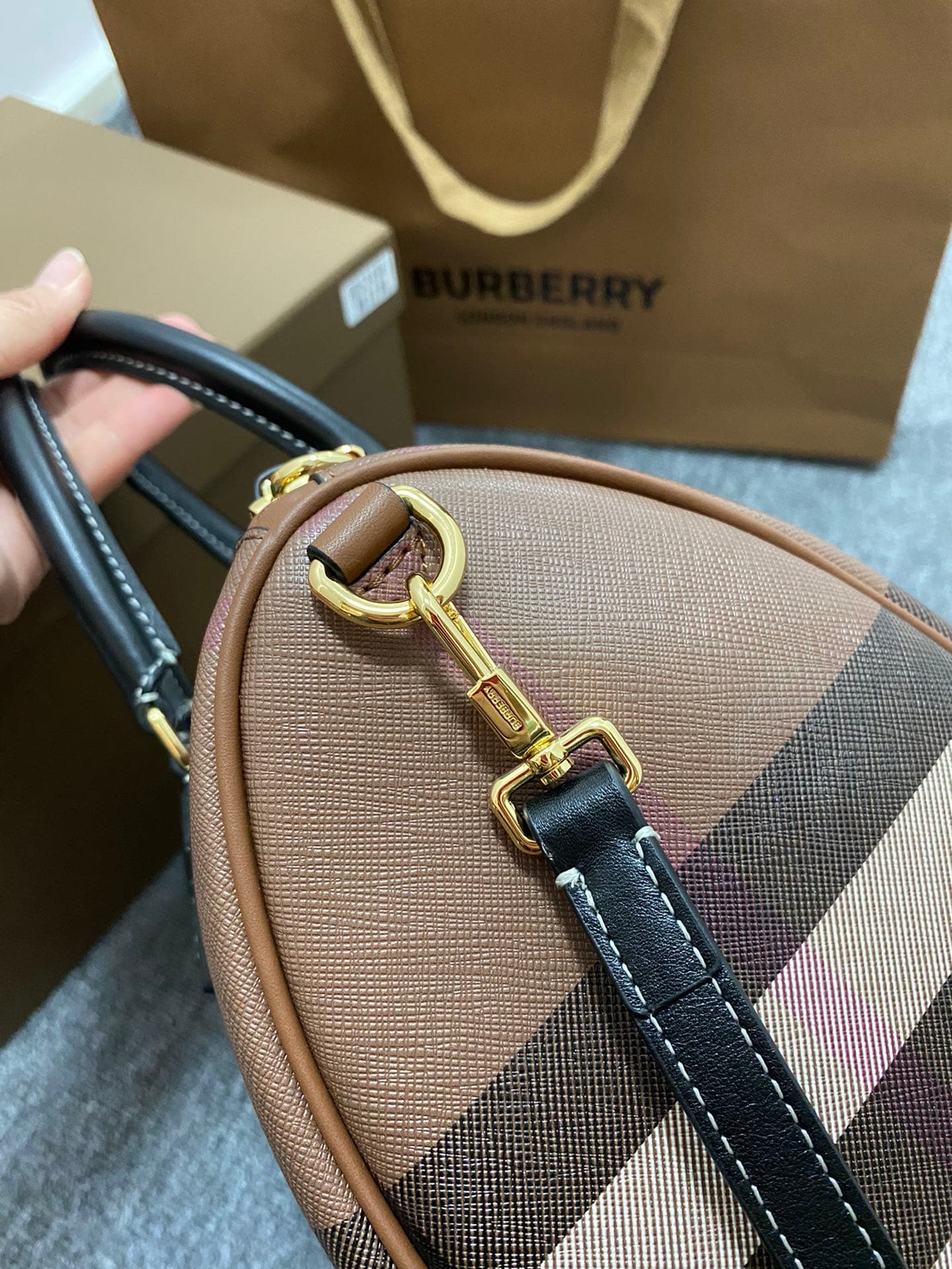 C68 The latest Italian-quality bowling bag from B brand is made of plaid material and leather with visible seams. It features a leather handle at the top, detachable and adjustable shoulder straps, zippers, as well as a leather-lined lock and luggage tag. — image 2