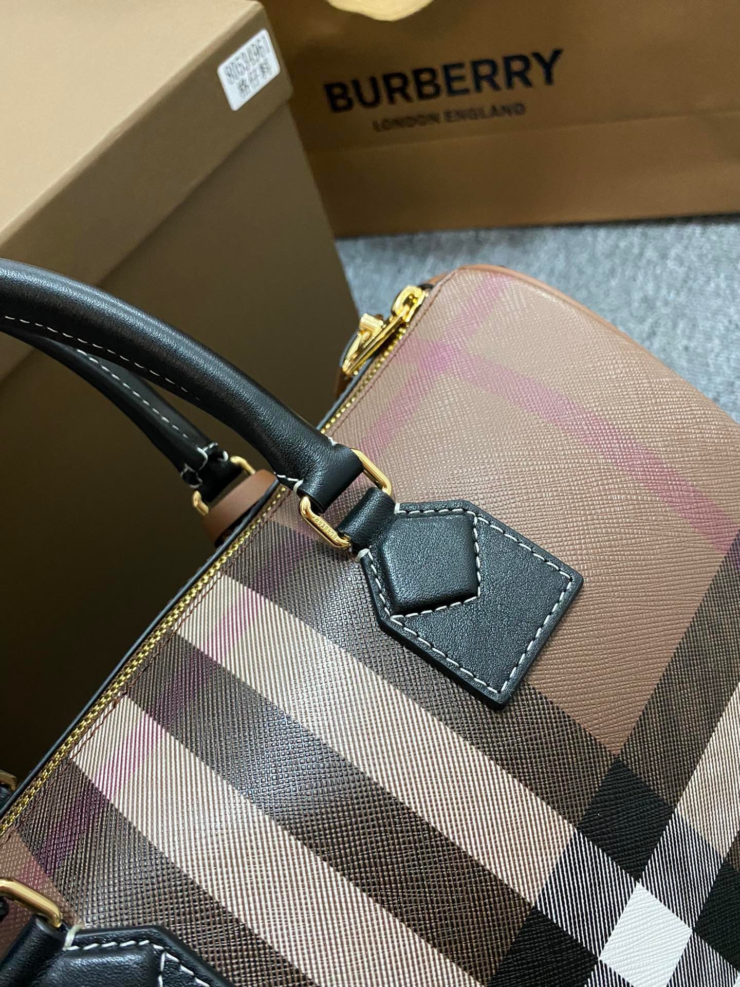 C68 The latest Italian-quality bowling bag from B brand is made of plaid material and leather with visible seams. It features a leather handle at the top, detachable and adjustable shoulder straps, zippers, as well as a leather-lined lock and luggage tag. — image 3