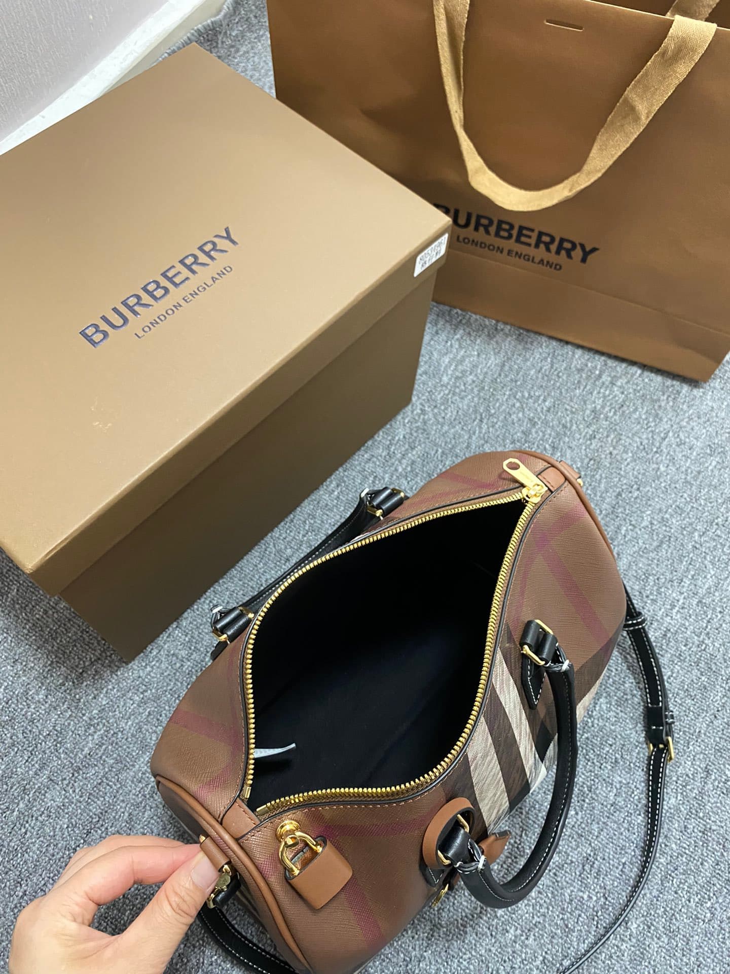 C68 The latest Italian-quality bowling bag from B brand is made of plaid material and leather with visible seams. It features a leather handle at the top, detachable and adjustable shoulder straps, zippers, as well as a leather-lined lock and luggage tag. — image 8