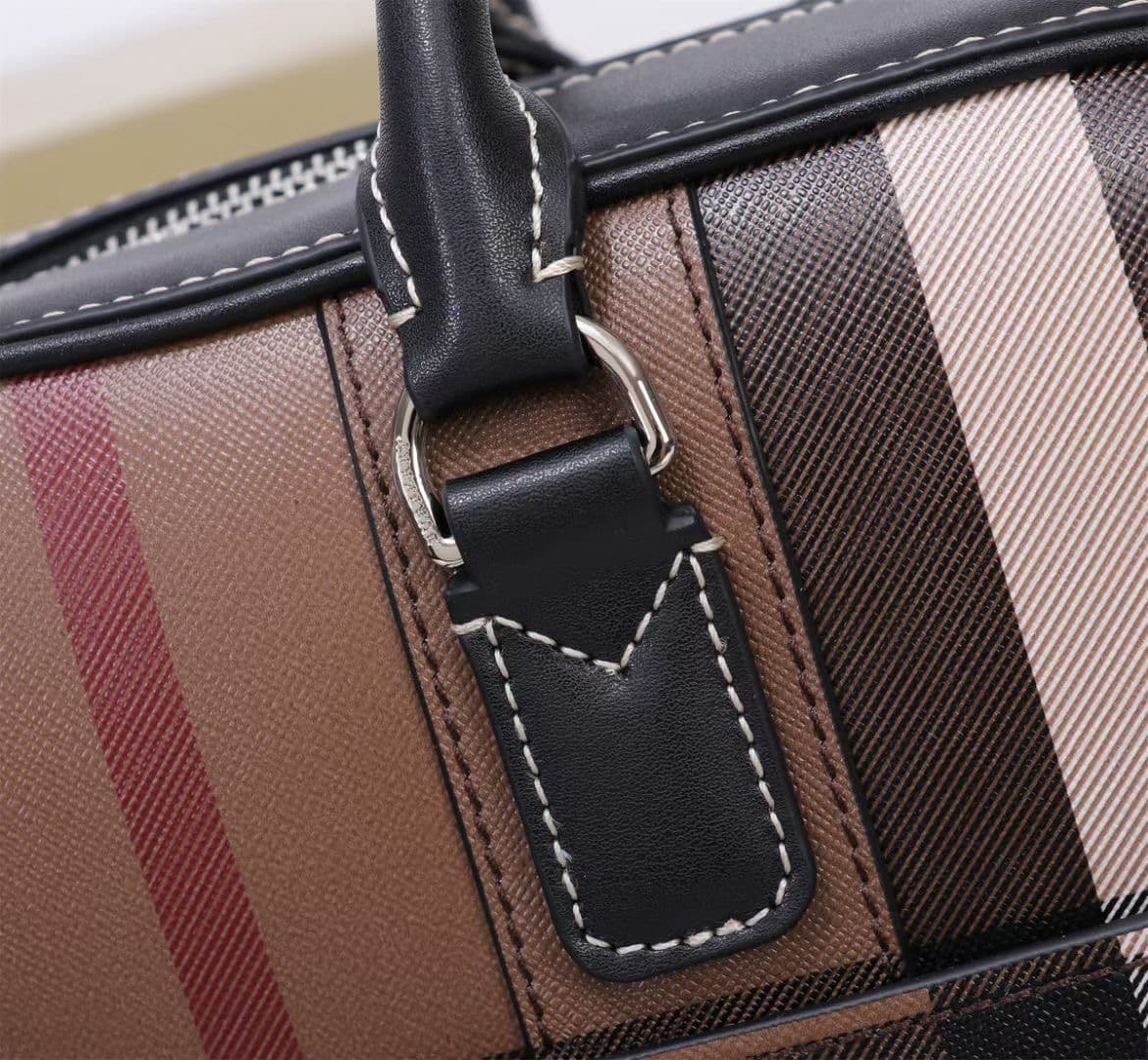 C8230 -B Brand’s latest briefcase is crafted from checked and Italian tanned leather, with a branded logo design. It can be carried in a handbag style, or worn on the shoulder using detachable straps. At least 30% of the materials used in this product are — image 5
