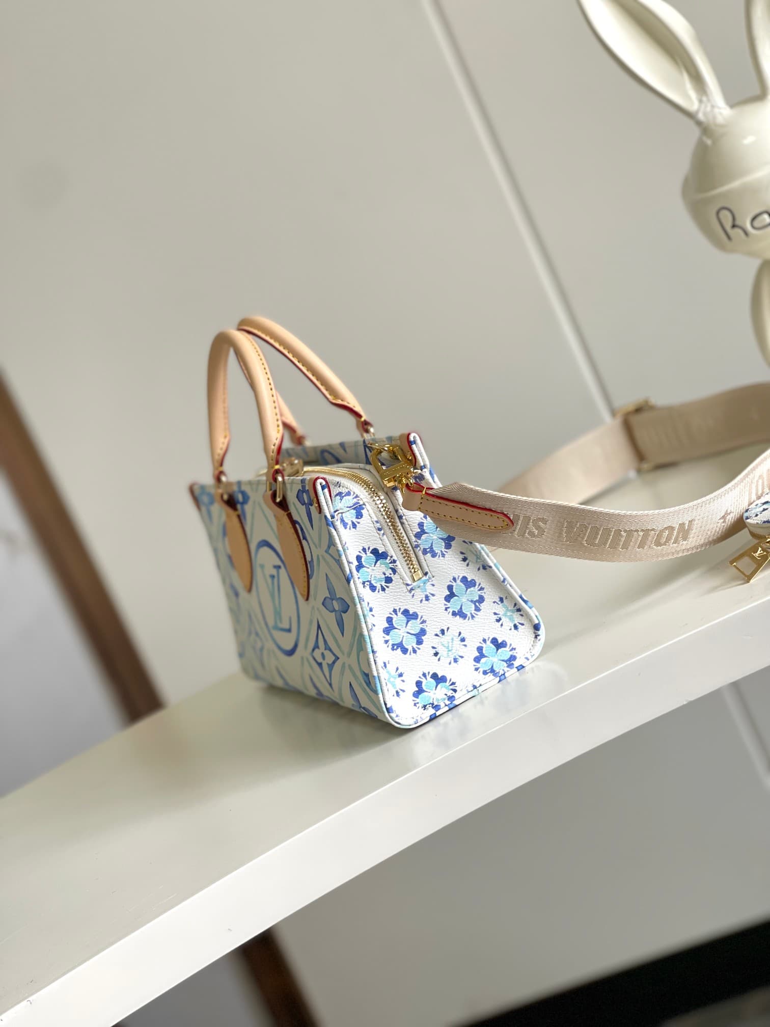 C5175 [Haiyuan Outer Single Independent Purchase] M25318 Blue model OnTheGo East West handbag features a unique design and is made of canvas. It is one of the popular products in the LV By The Pool collection. The LV Circle and Monogram Flowers patterns f — image 2