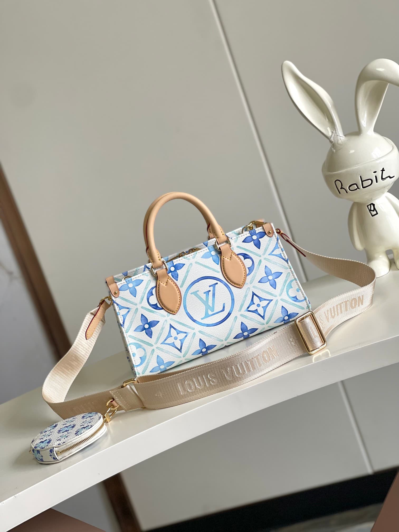 C5175 [Haiyuan Outer Single Independent Purchase] M25318 Blue model OnTheGo East West handbag features a unique design and is made of canvas. It is one of the popular products in the LV By The Pool collection. The LV Circle and Monogram Flowers patterns f — image 1