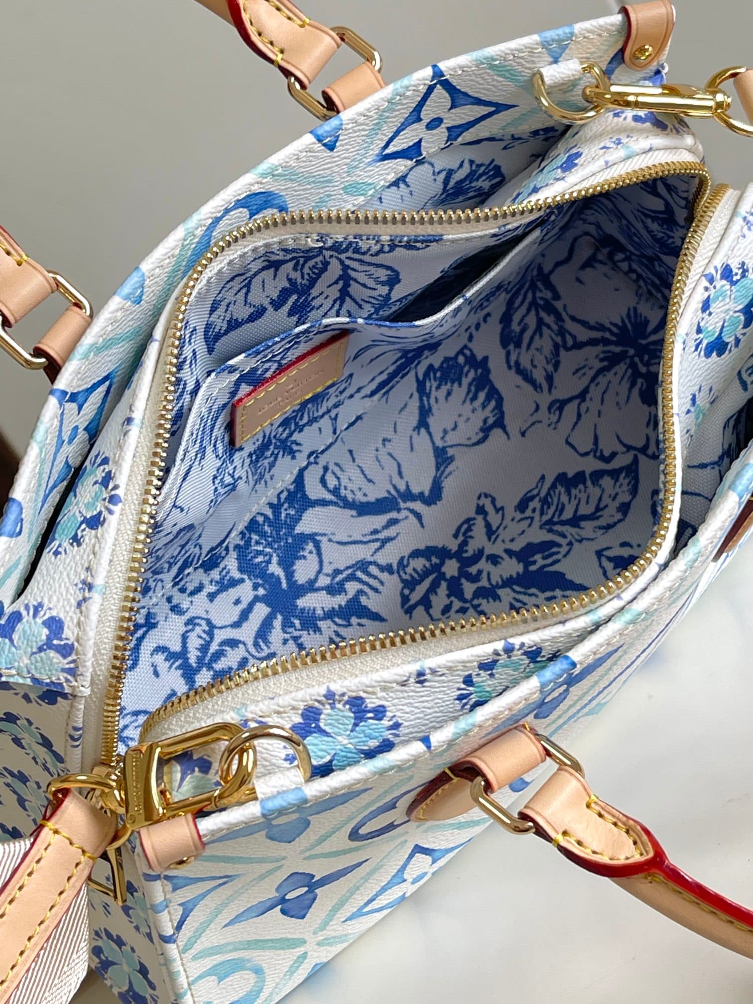 C5175 [Haiyuan Outer Single Independent Purchase] M25318 Blue model OnTheGo East West handbag features a unique design and is made of canvas. It is one of the popular products in the LV By The Pool collection. The LV Circle and Monogram Flowers patterns f — image 8