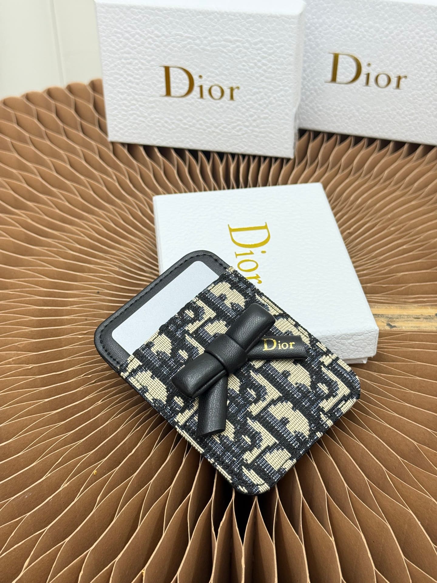 C390 This Lady Dior magnet card case is a delicate accessory that showcases the brand’s exquisite craftsmanship. The Cannage pattern in thread motif and the leather design are adorned with intricate bow ties – these are new elements of the Dior logo, high — image 2