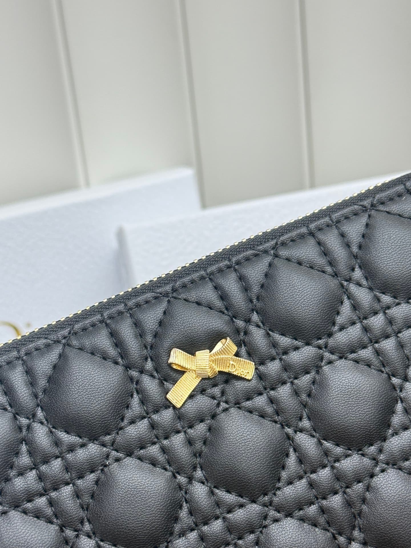 C403 This thin silver wallet from Baby Bow Voyageur is an essential accessory, exuding a simple and elegant style. The black mini boucle pattern on the lamb leather, combined with delicate bow ties, offers a clever new interpretation of the classic brand’ — image 5