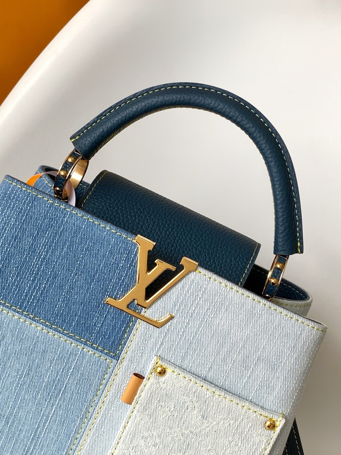 C5264 💰M27302 – Premium original style. The Capucines BB handbag features a denim material, reflecting contemporary fashion trends; its unique color-blocked design is truly distinctive. The bag comes with Taurillon leather handles, a flap closure, and a d — image 5