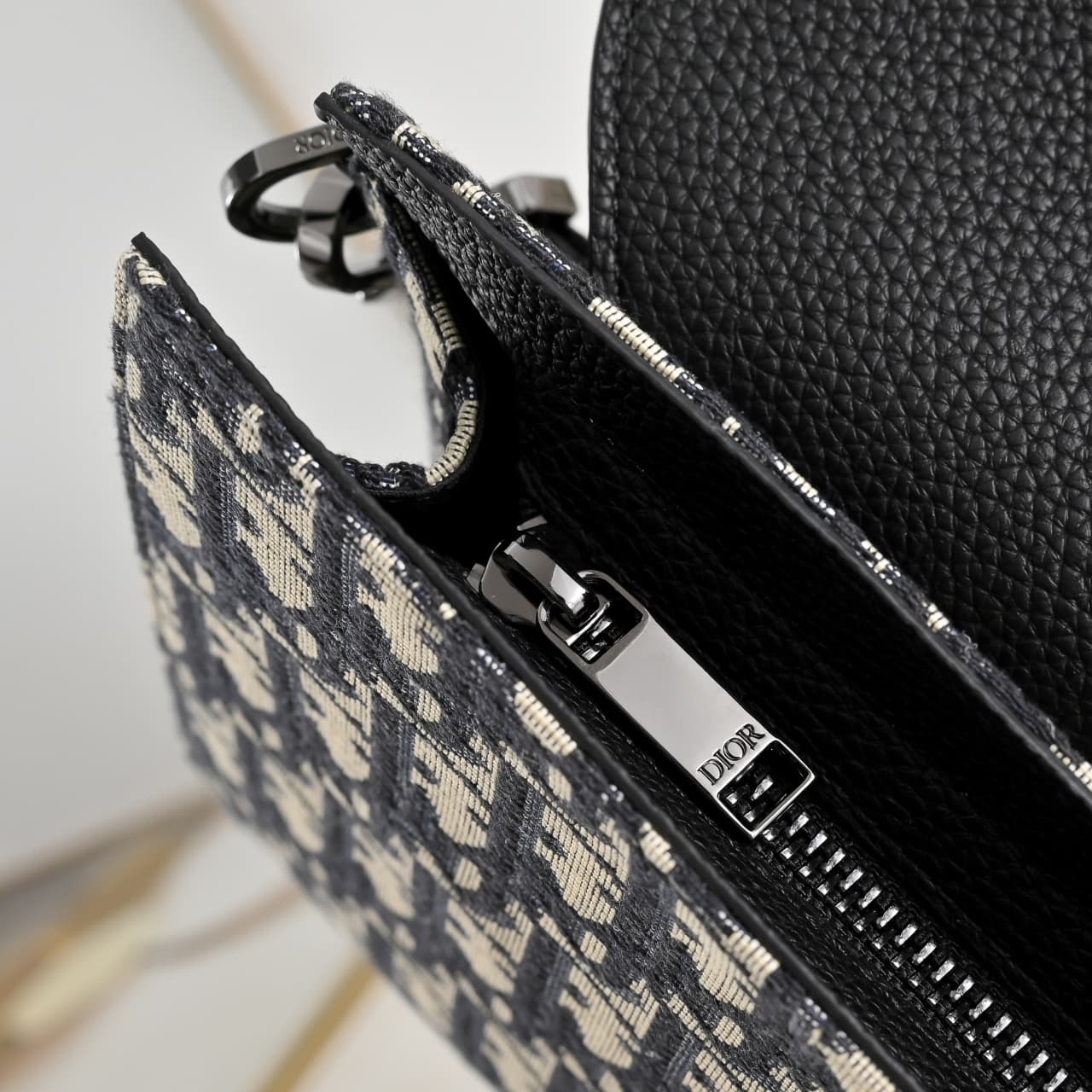 C1818 The A5 triangle-handbag is a new flagship product. It is crafted from beige and black Oblique-printed fabric, along with black suede leather with a saddle-shaped flap design. The spacious zipper compartment can hold a phone, and there are also card  — image 7