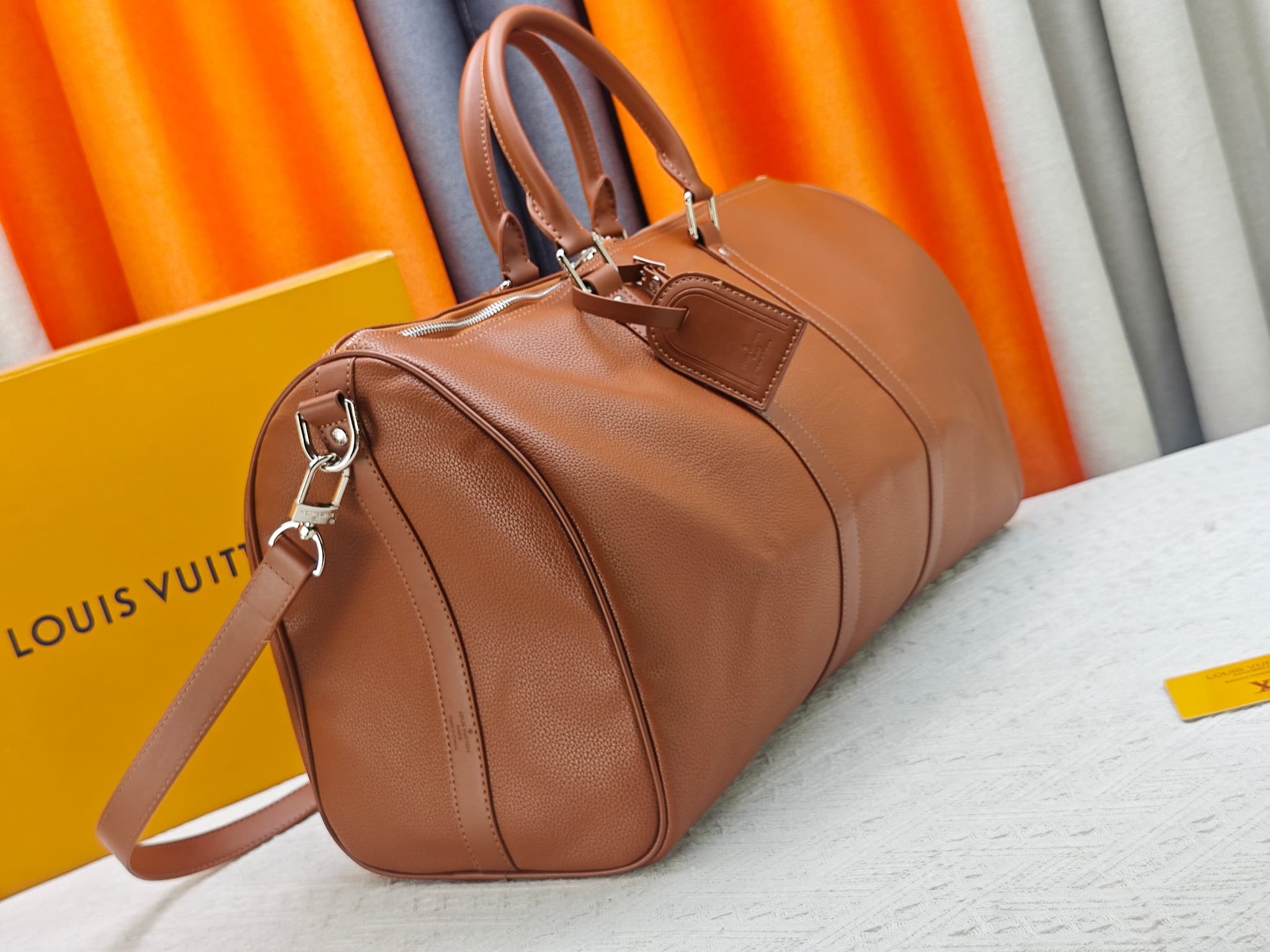 C5291 M41416 M26065 Brown. This Keepall Bandouliere 50 travel bag is made from polished cowhide leather and fabric lining, making it an excellent choice for weekend trips. The fine, soft leather and the LV logo exude elegance; the handle at the top and th — image 3