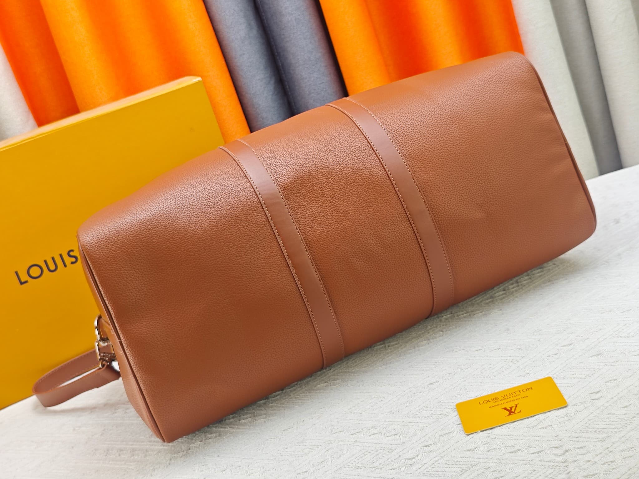 C5291 M41416 M26065 Brown. This Keepall Bandouliere 50 travel bag is made from polished cowhide leather and fabric lining, making it an excellent choice for weekend trips. The fine, soft leather and the LV logo exude elegance; the handle at the top and th — image 5