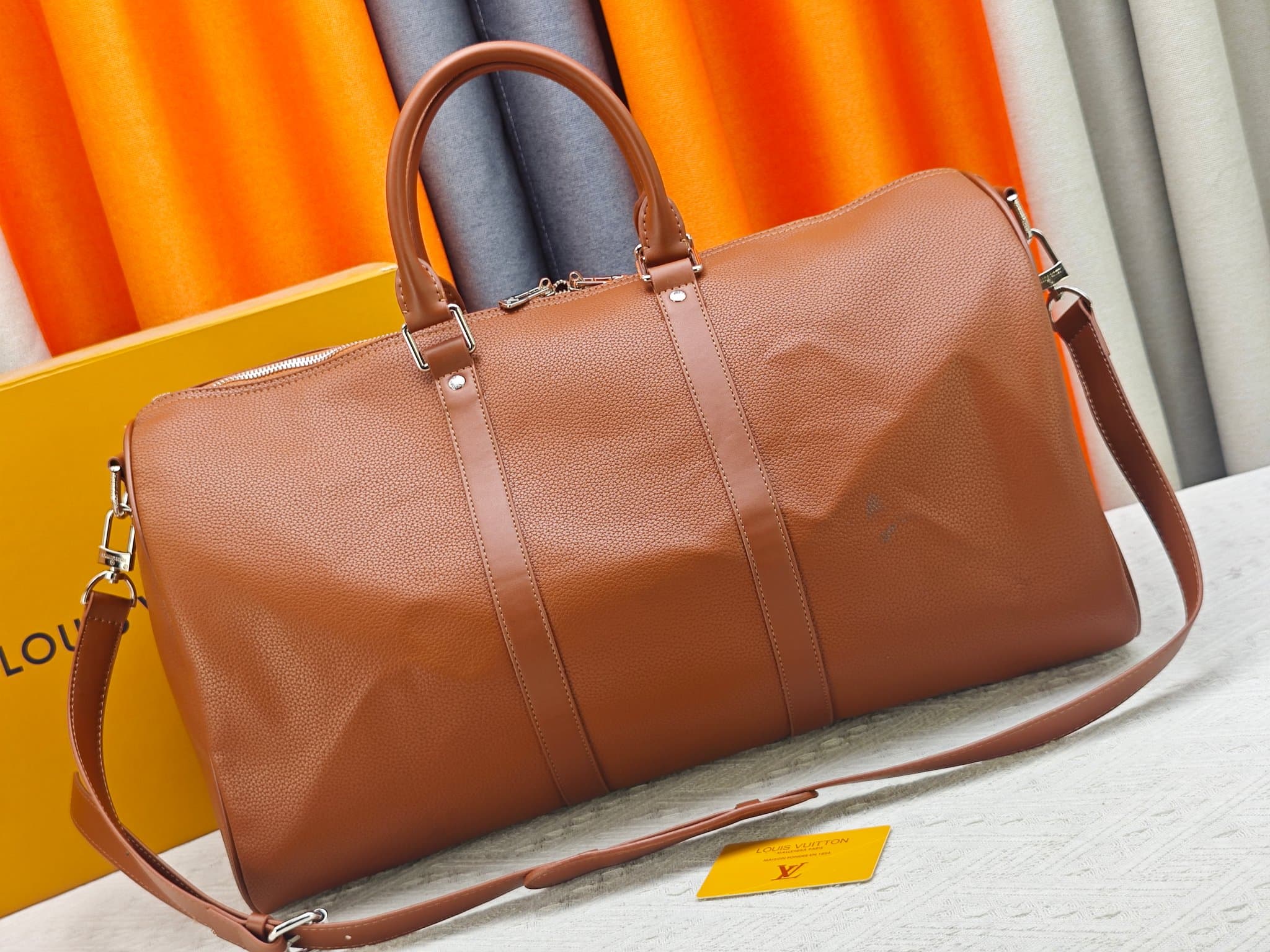 C5291 M41416 M26065 Brown. This Keepall Bandouliere 50 travel bag is made from polished cowhide leather and fabric lining, making it an excellent choice for weekend trips. The fine, soft leather and the LV logo exude elegance; the handle at the top and th — image 4