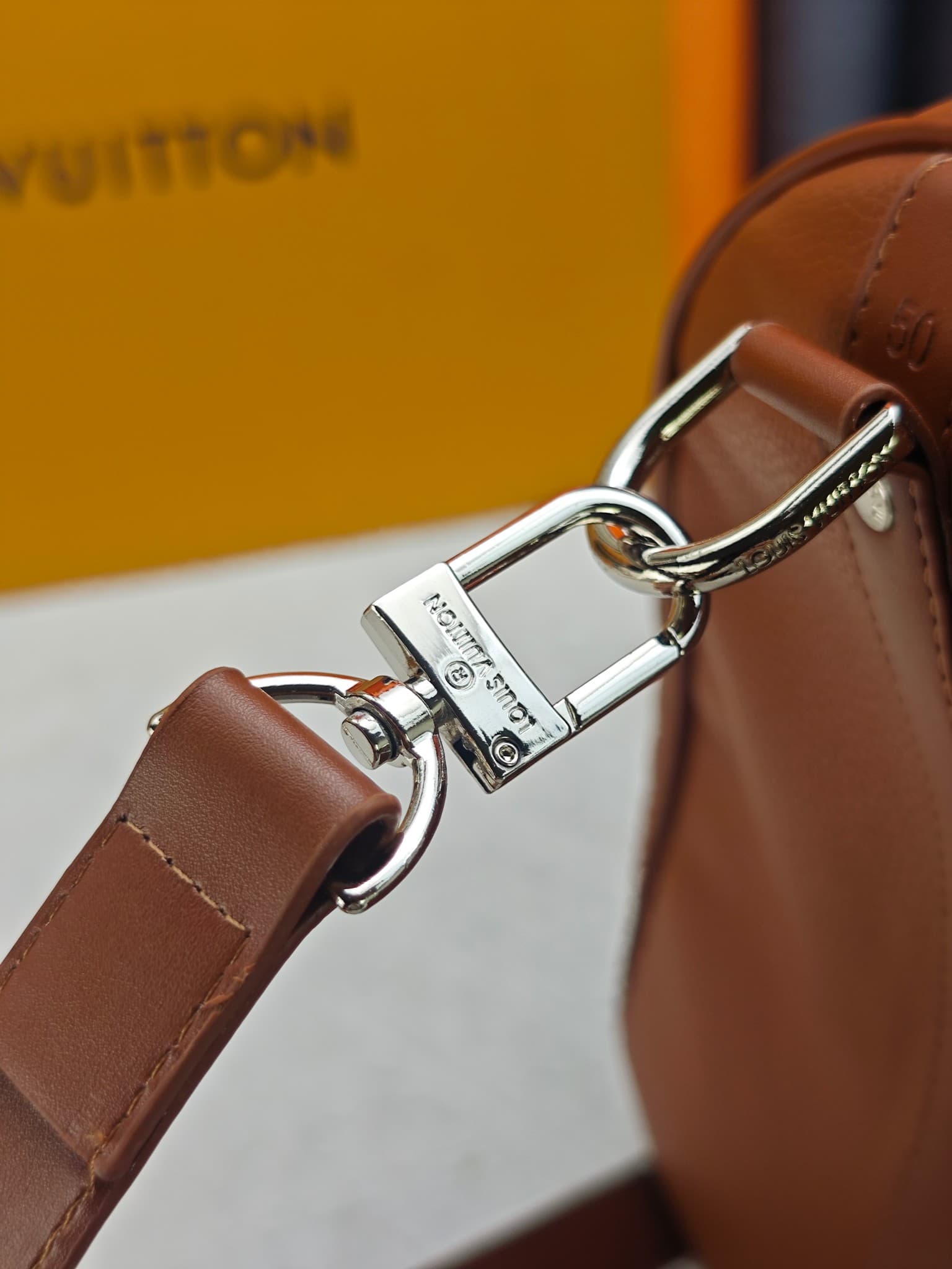 C5291 M41416 M26065 Brown. This Keepall Bandouliere 50 travel bag is made from polished cowhide leather and fabric lining, making it an excellent choice for weekend trips. The fine, soft leather and the LV logo exude elegance; the handle at the top and th — image 6