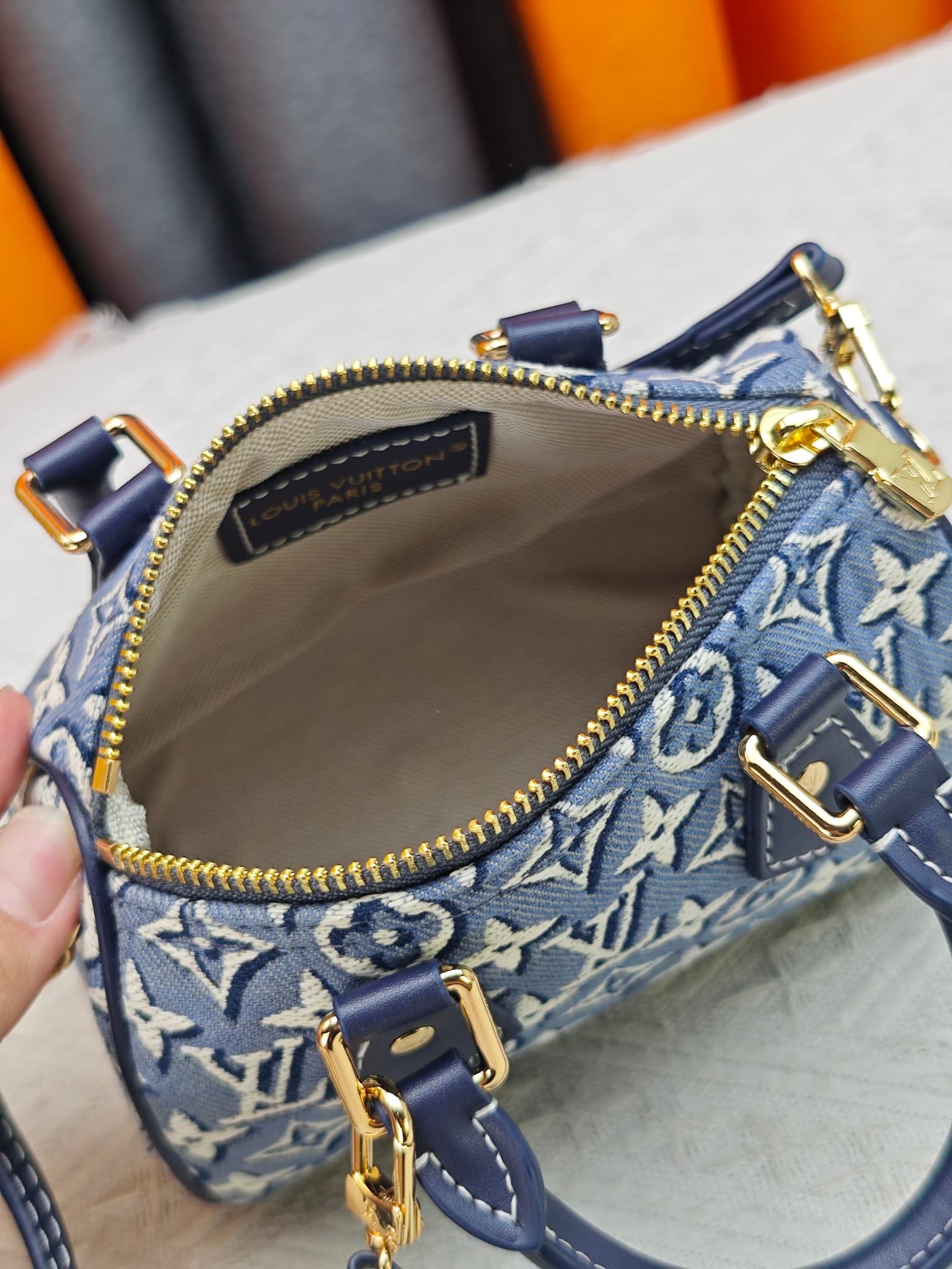 C5055 M28502  2A187  M81085 Batik. This Nano Speedy handbag features a delicate batik canvas design adorned with the Monogram Emblème logo. The bag’s body is styled in the traditional hard shell colors of the brand, and it comes with contrasting leather t — image 8