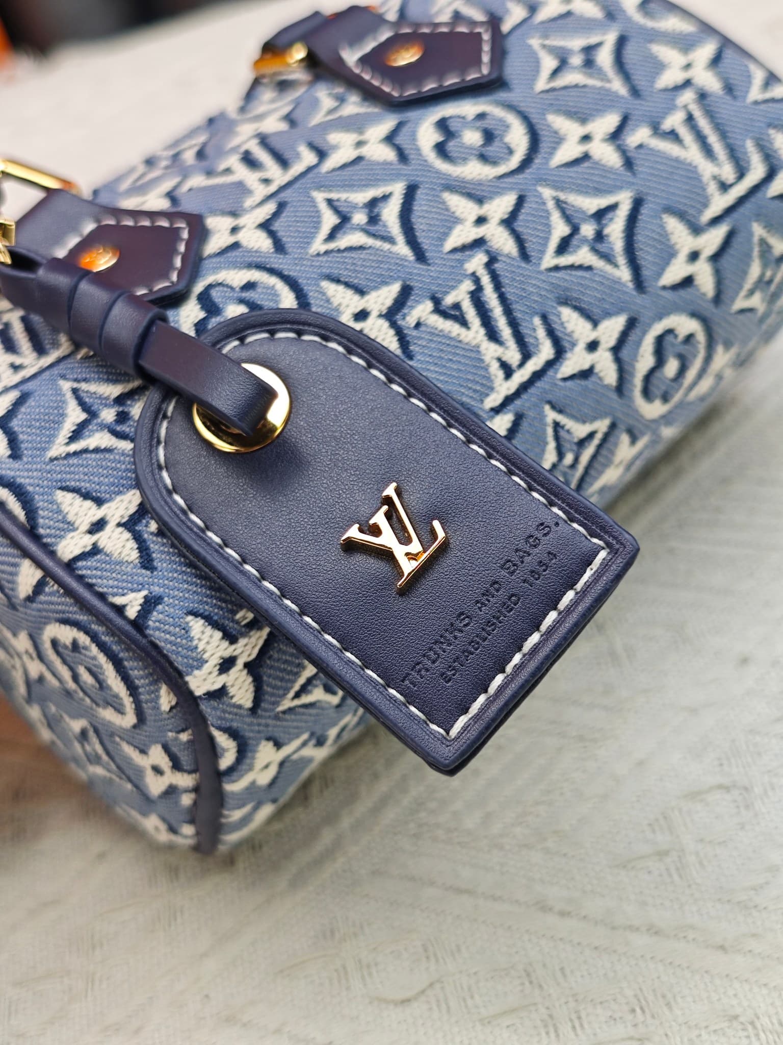 C5055 M28502  2A187  M81085 Batik. This Nano Speedy handbag features a delicate batik canvas design adorned with the Monogram Emblème logo. The bag’s body is styled in the traditional hard shell colors of the brand, and it comes with contrasting leather t — image 6