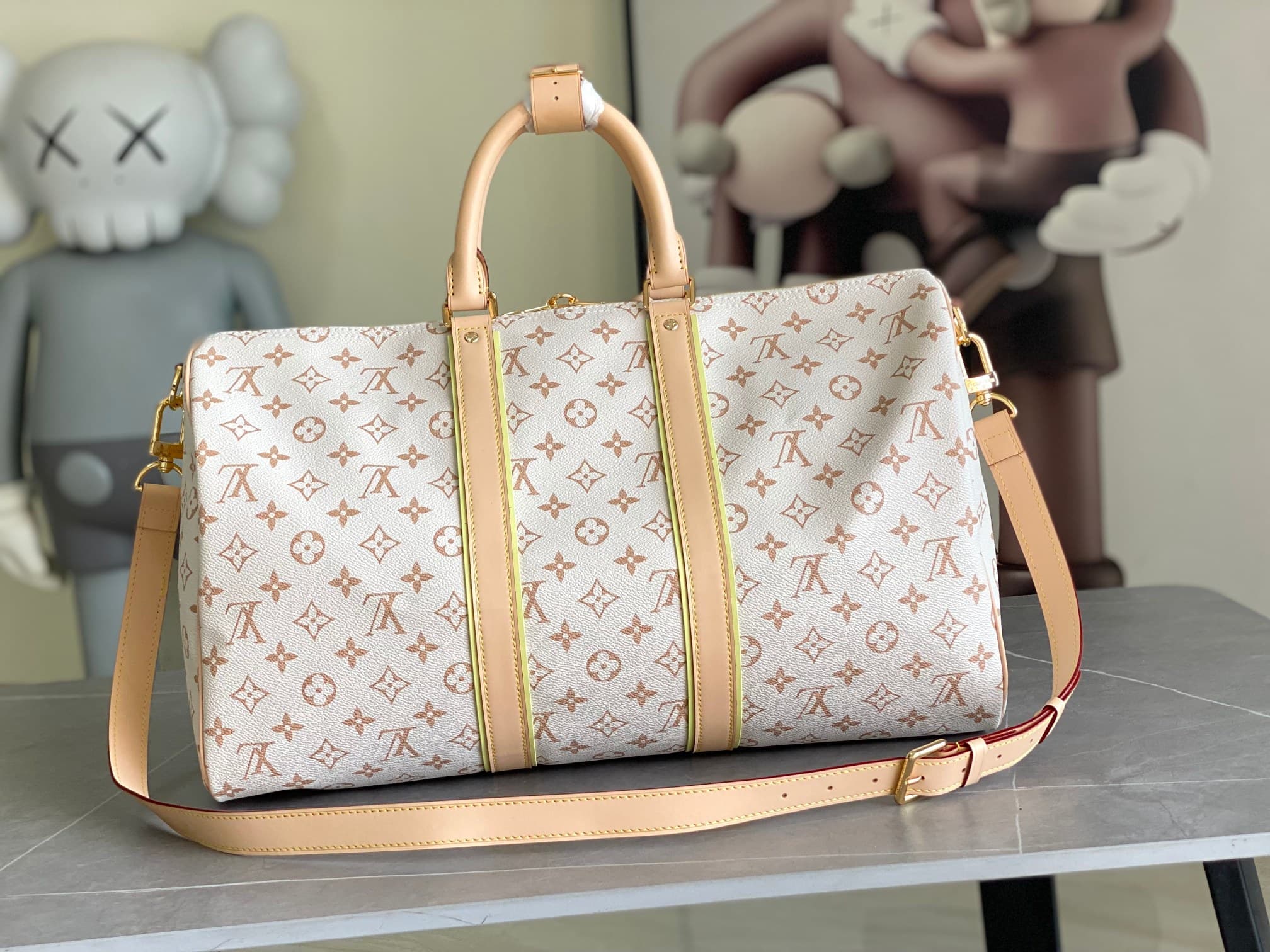 C5110 M29674 – White color; 163c01 – Dynamic design. This Keepall Bandoulière 45 travel bag is made from Monogram Dune-coated canvas, reflecting a casual style. Detailed craftsmanship is evident in the leather trim and the hand-sewn LV Crafty name tag. Th — image 3