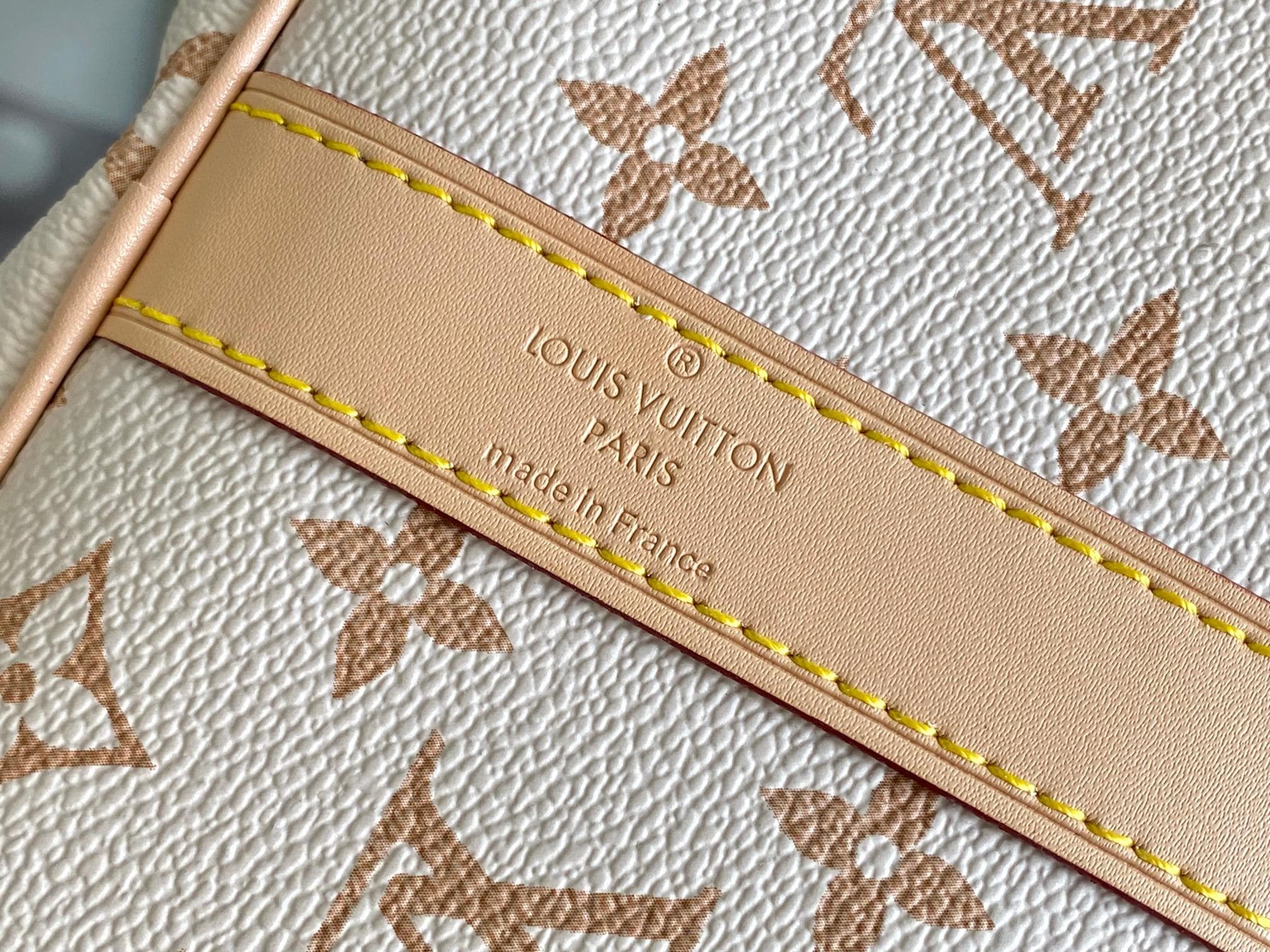 C5110 M29674 – White color; 163c01 – Dynamic design. This Keepall Bandoulière 45 travel bag is made from Monogram Dune-coated canvas, reflecting a casual style. Detailed craftsmanship is evident in the leather trim and the hand-sewn LV Crafty name tag. Th — image 6