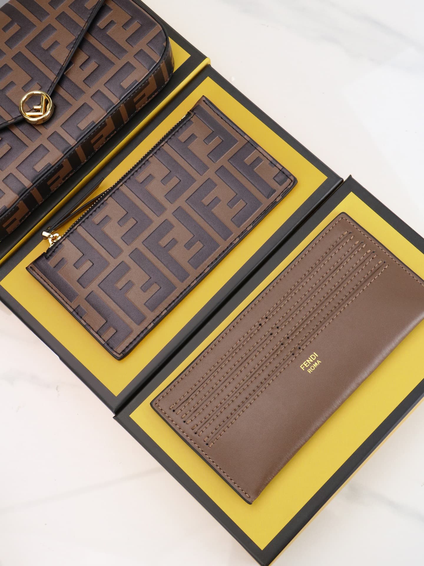C2870 Fendi mini handbag with geometric patterns, featuring a flap closure and zipper opening. It has a detachable chain strap. The interior is equipped with flat pockets. The bag’s exterior is made of distinctive brown leather with black raised FF prints — image 7