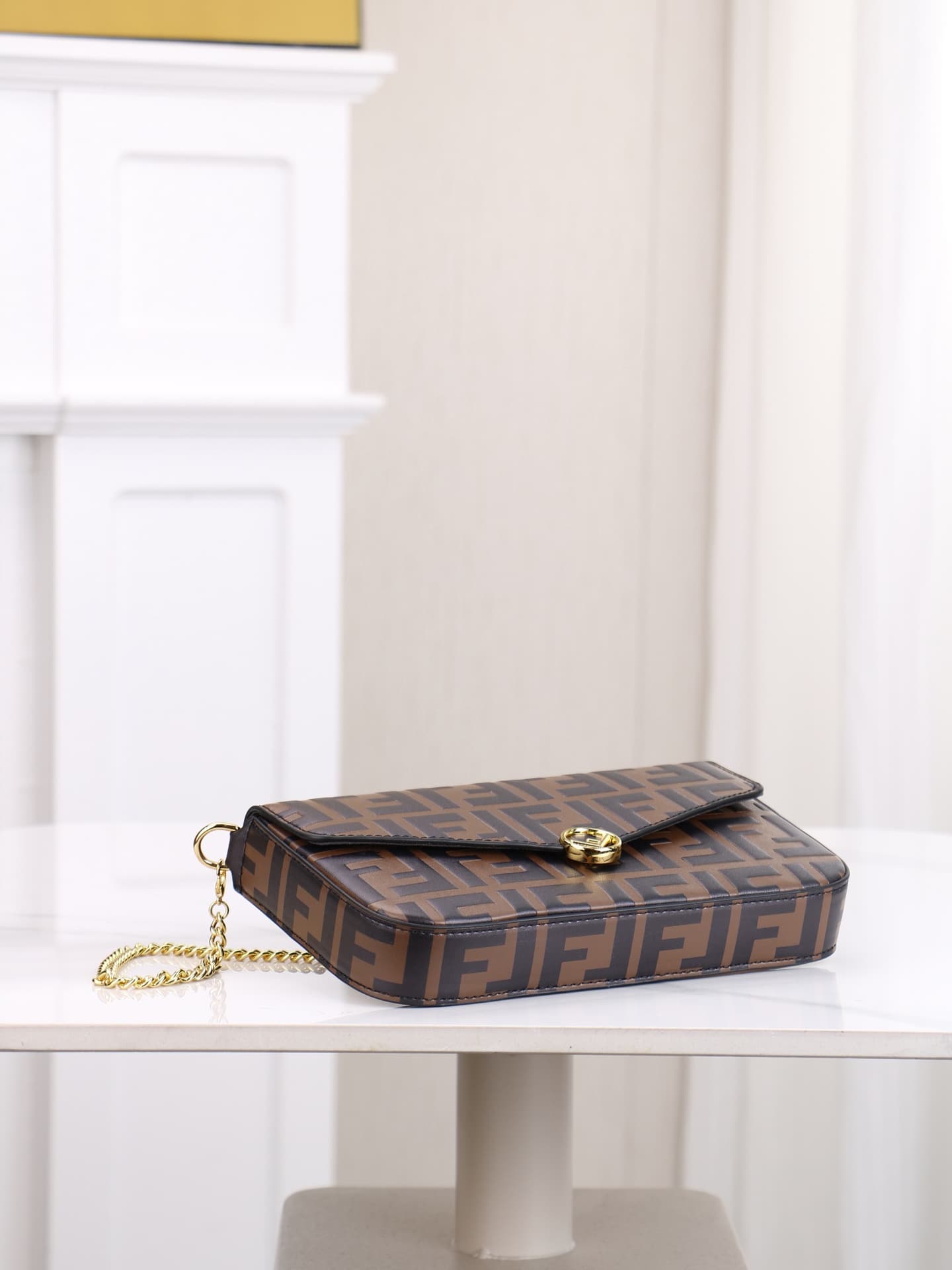 C2870 Fendi mini handbag with geometric patterns, featuring a flap closure and zipper opening. It has a detachable chain strap. The interior is equipped with flat pockets. The bag’s exterior is made of distinctive brown leather with black raised FF prints — image 4