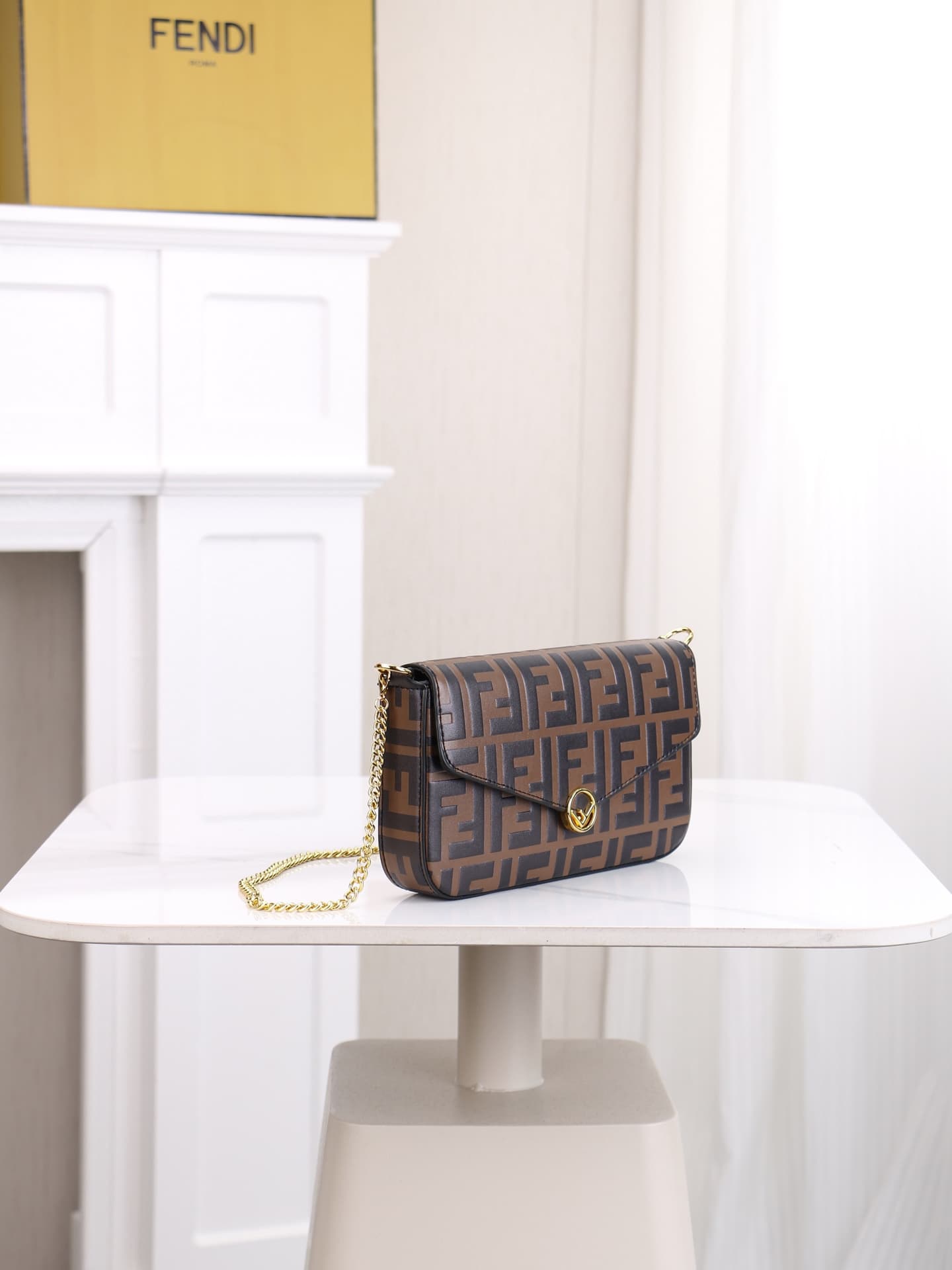 C2870 Fendi mini handbag with geometric patterns, featuring a flap closure and zipper opening. It has a detachable chain strap. The interior is equipped with flat pockets. The bag’s exterior is made of distinctive brown leather with black raised FF prints — image 2