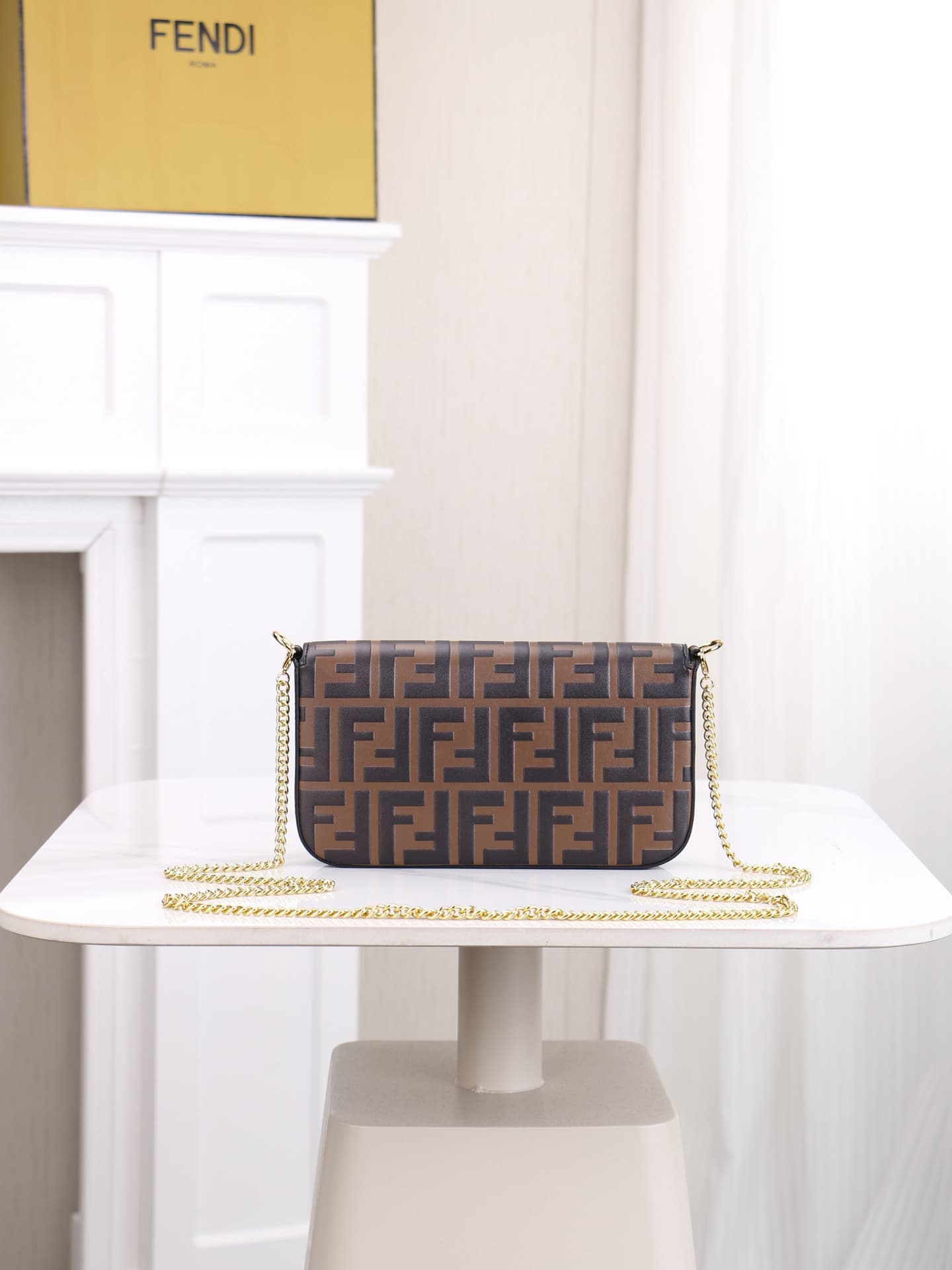C2870 Fendi mini handbag with geometric patterns, featuring a flap closure and zipper opening. It has a detachable chain strap. The interior is equipped with flat pockets. The bag’s exterior is made of distinctive brown leather with black raised FF prints — image 3