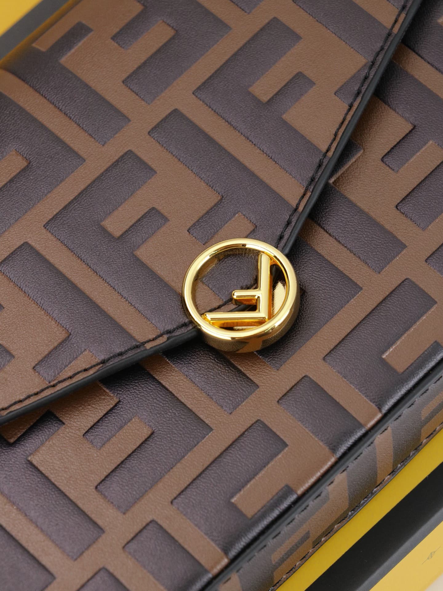 C2870 Fendi mini handbag with geometric patterns, featuring a flap closure and zipper opening. It has a detachable chain strap. The interior is equipped with flat pockets. The bag’s exterior is made of distinctive brown leather with black raised FF prints — image 5