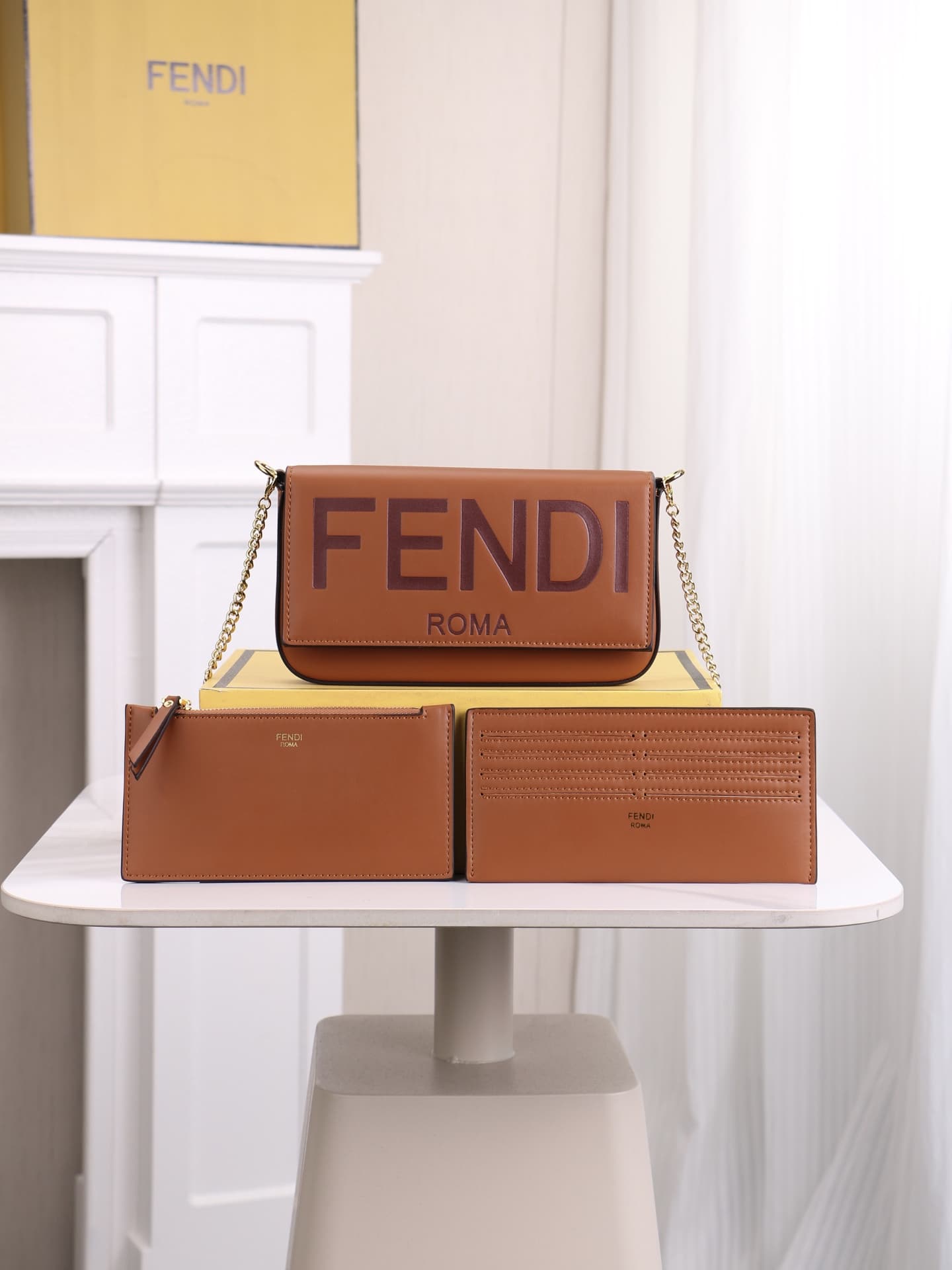 C2865 Fendi mini handbag with geometric pattern flap, featuring a zipper closure. Detachable chain strap. Interior lined with flat pockets. The bag is made of iconic brown leather with black raised FF print; it comes with two detachable inner pockets – on — image 1