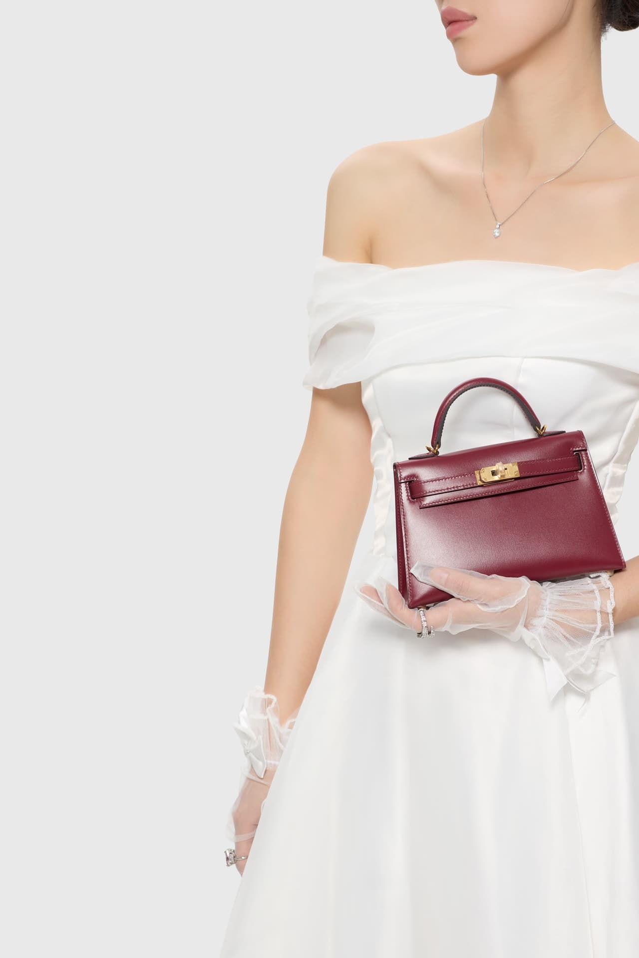 C4856 The white veil reflects purity; Kelly19 embodies Hermès’ red accents and perfection. The mini-sized design does not restrict the fluffy skirt edge; the intense red leather contrasts with the white satin. The H-button pairs well with the diamond deco — image 7