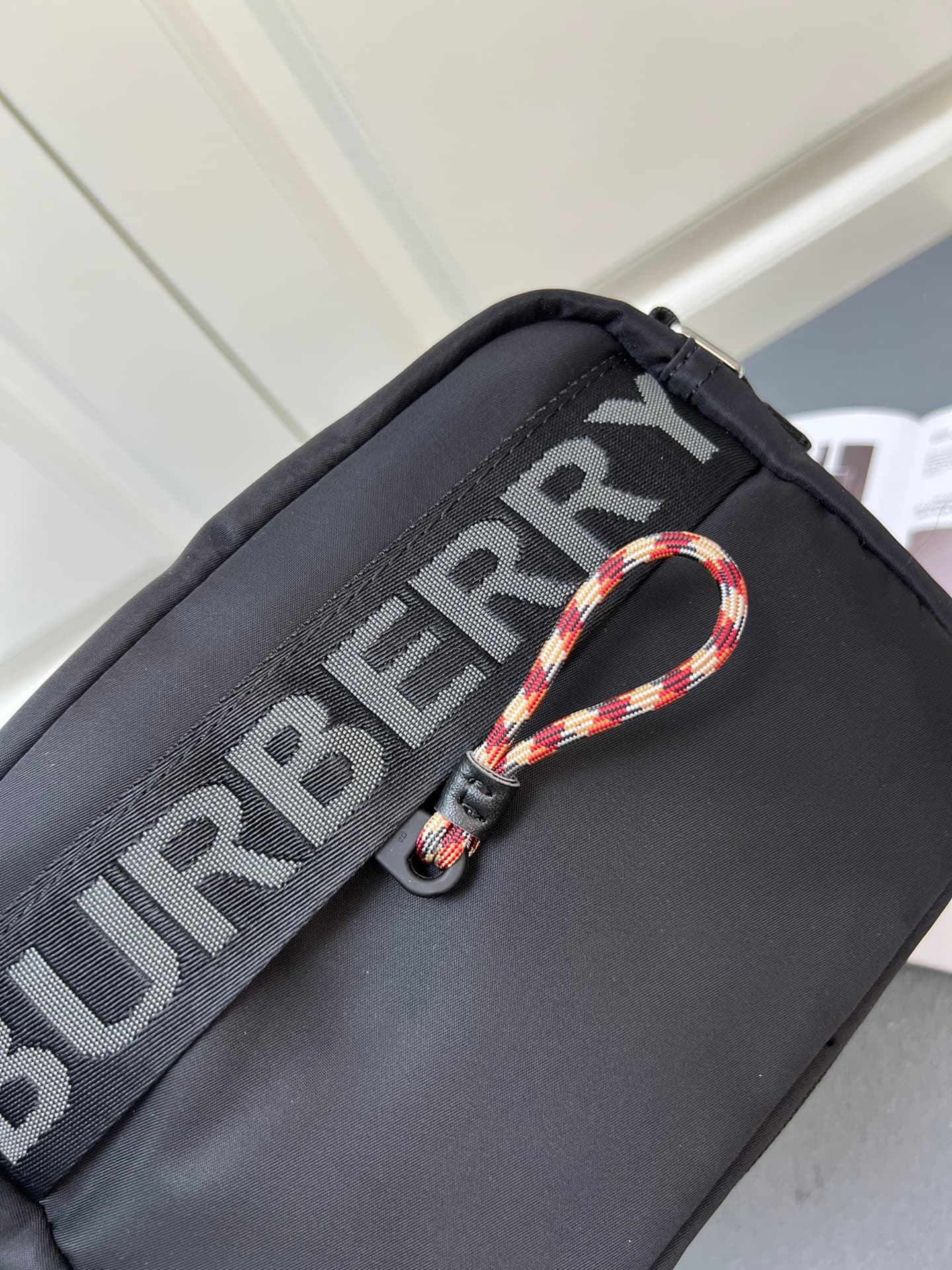 C37 [Brand B] 200: A vibrant decorative bag with a checked pattern in the “Paddy” style, featuring a brand logo embroidered on the strap. Adjustable diagonal shoulder strap; a zipper pocket; a magnetic closure external pocket. The zipper closure is also a — image 5