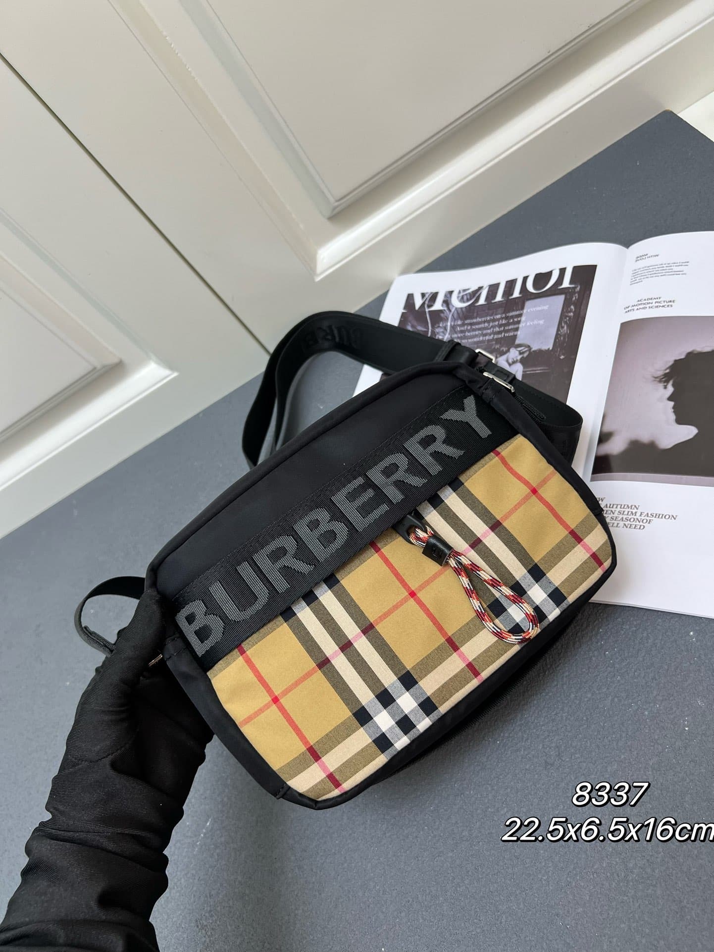 C36 [Brand B] 200: A vibrant decorative bag with a plaid pattern in the “Bur” style. It features a strap with a brand logo embroidered on it. There is an adjustable diagonal shoulder strap, as well as a zipper pocket. The 1 external pocket is opened using — image 2