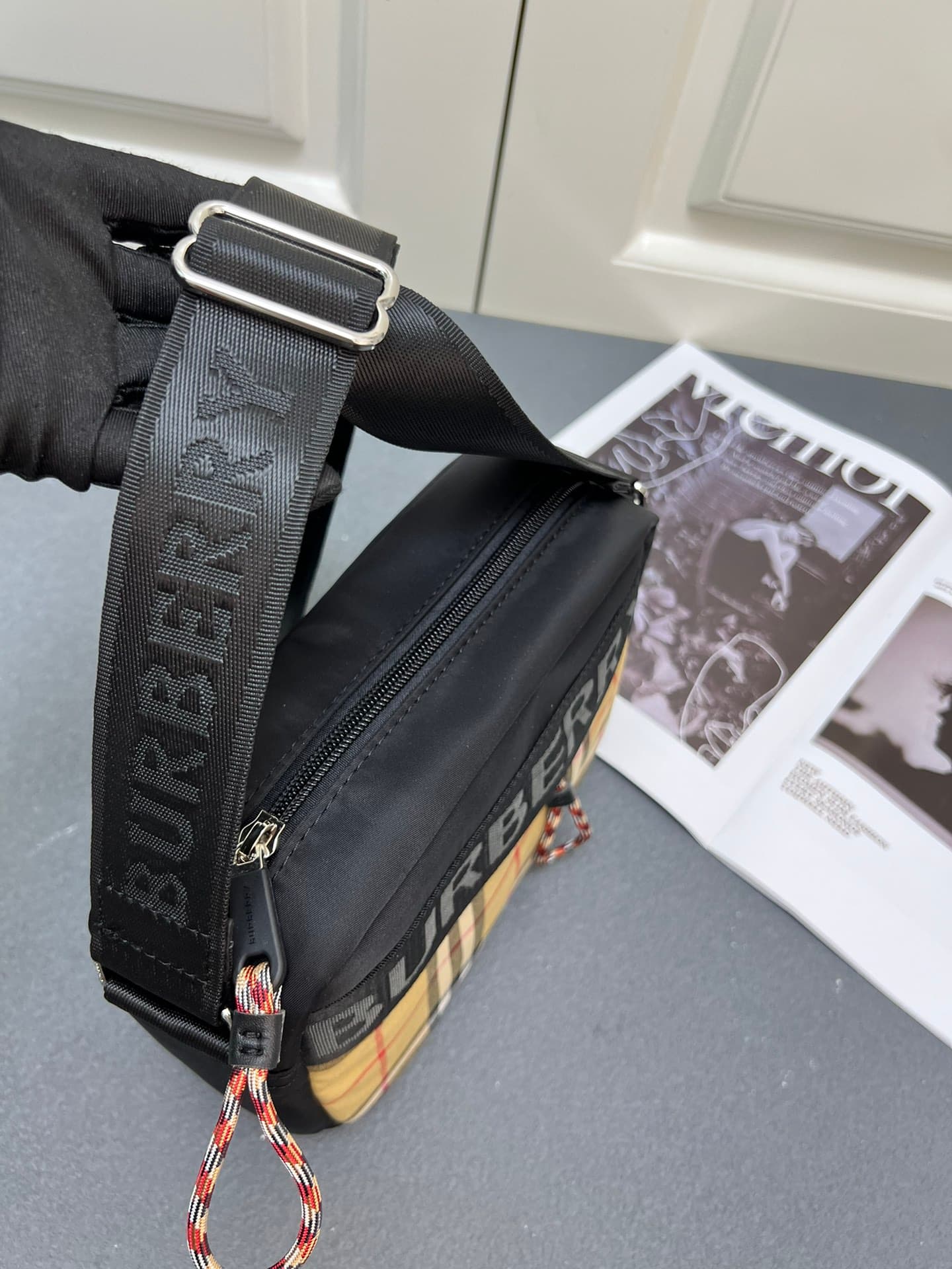 C36 [Brand B] 200: A vibrant decorative bag with a plaid pattern in the “Bur” style. It features a strap with a brand logo embroidered on it. There is an adjustable diagonal shoulder strap, as well as a zipper pocket. The 1 external pocket is opened using — image 4