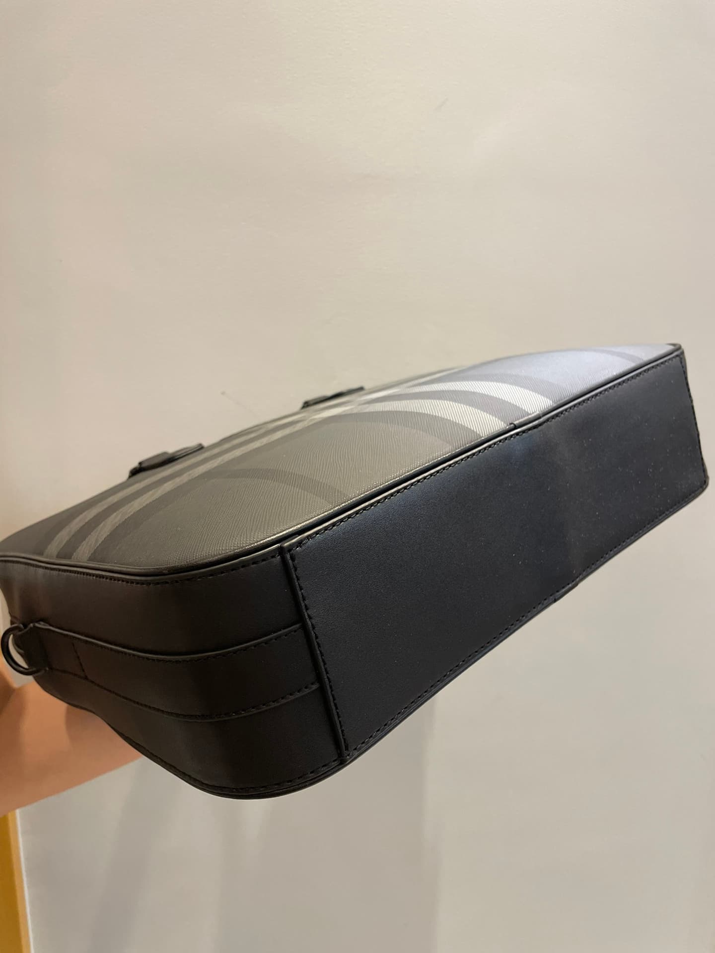 C8232 -B Brand’s latest briefcase is crafted from check pattern and Italian tanned leather, with a branded logo design. It can be carried in a handbag style, or it can be worn on the shoulder using detachable straps. At least 30% of the materials used in  — image 3