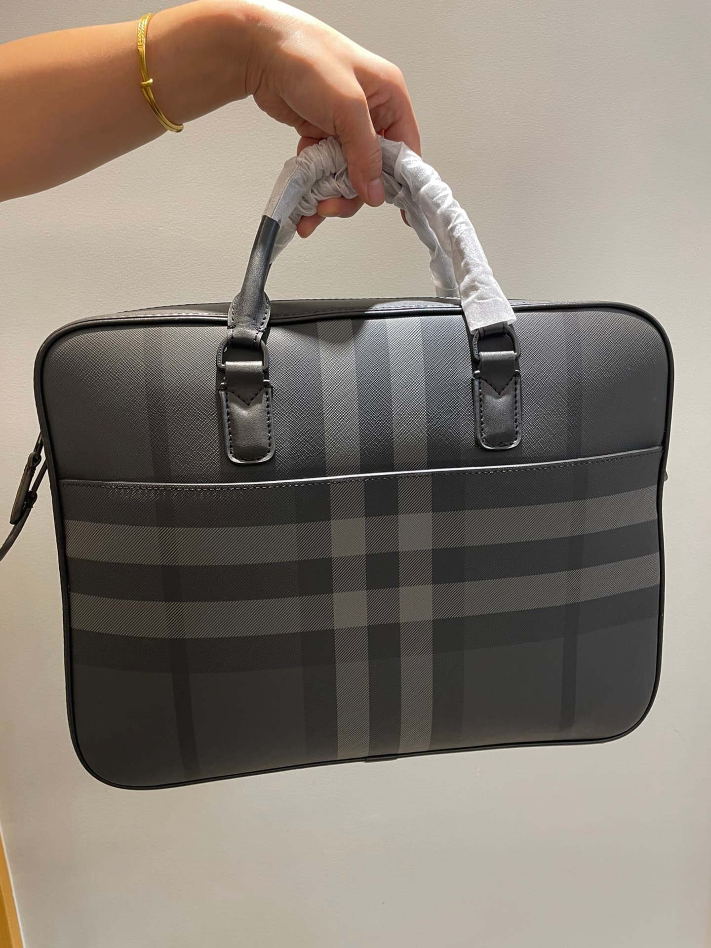 C8232 -B Brand’s latest briefcase is crafted from check pattern and Italian tanned leather, with a branded logo design. It can be carried in a handbag style, or it can be worn on the shoulder using detachable straps. At least 30% of the materials used in  — image 5