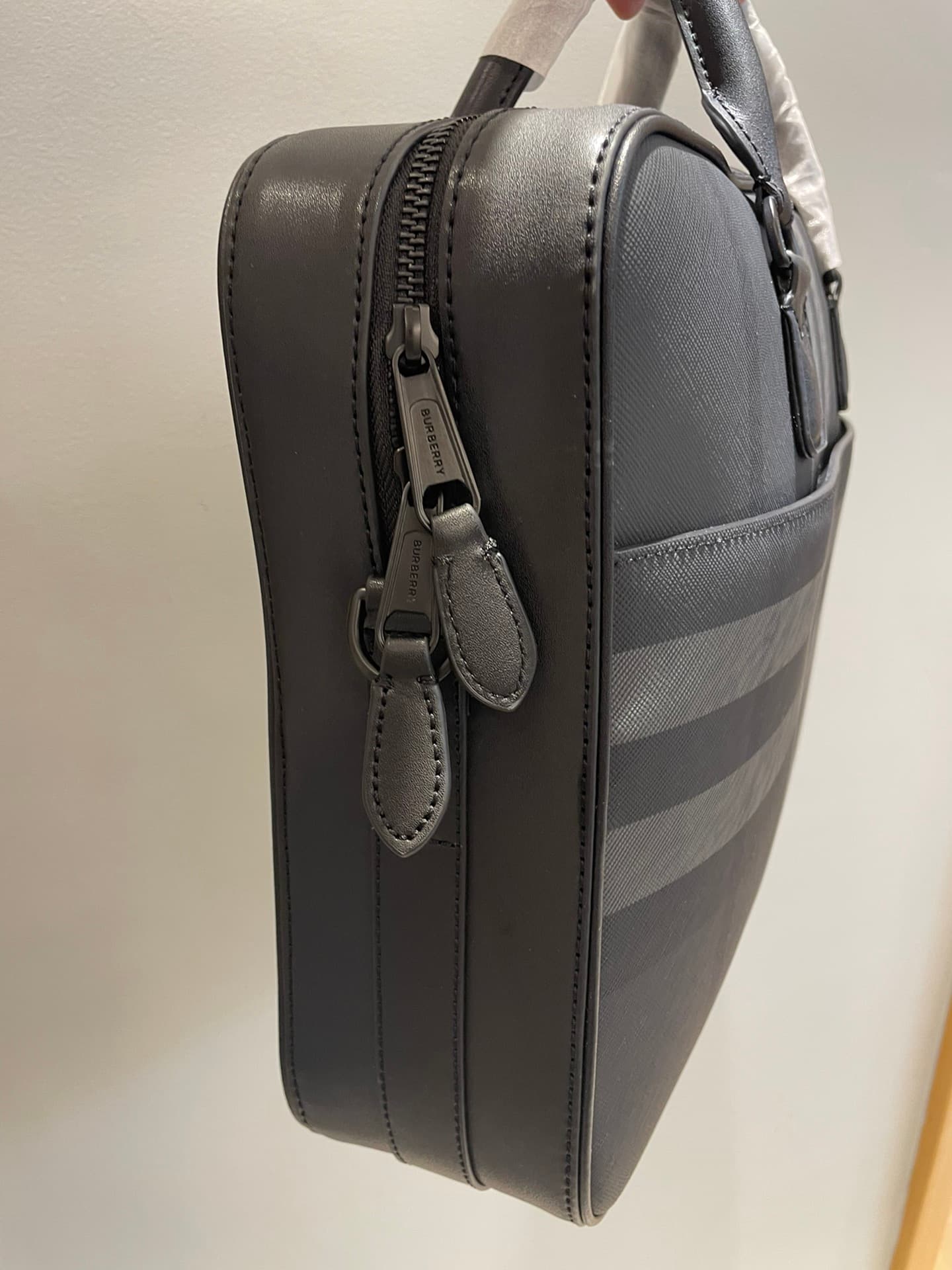 C8232 -B Brand’s latest briefcase is crafted from check pattern and Italian tanned leather, with a branded logo design. It can be carried in a handbag style, or it can be worn on the shoulder using detachable straps. At least 30% of the materials used in  — image 6