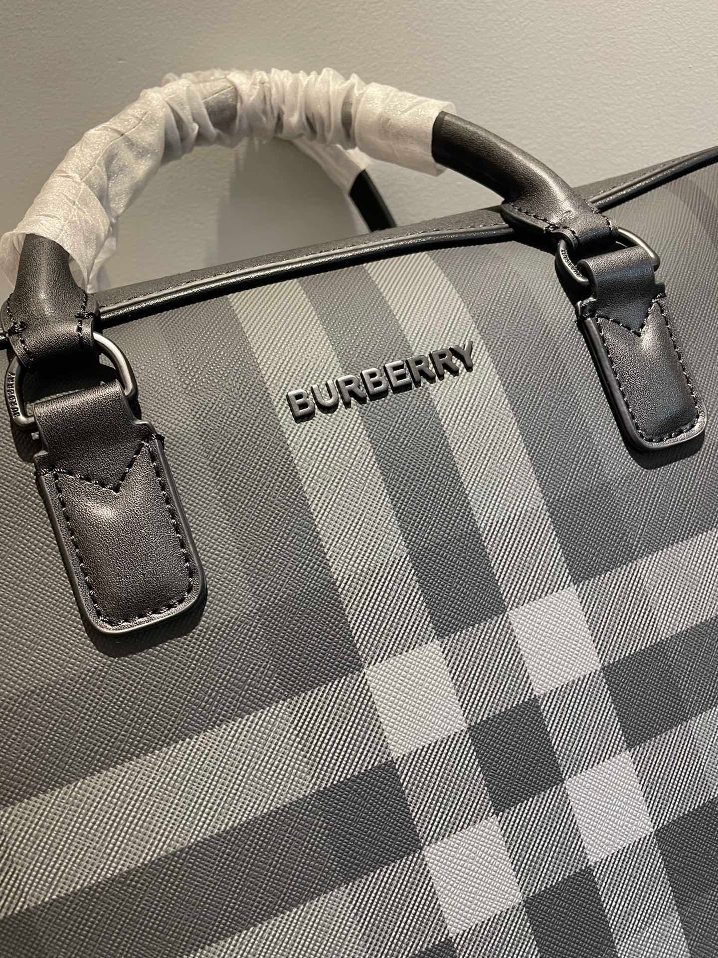 C8232 -B Brand’s latest briefcase is crafted from check pattern and Italian tanned leather, with a branded logo design. It can be carried in a handbag style, or it can be worn on the shoulder using detachable straps. At least 30% of the materials used in  — image 4