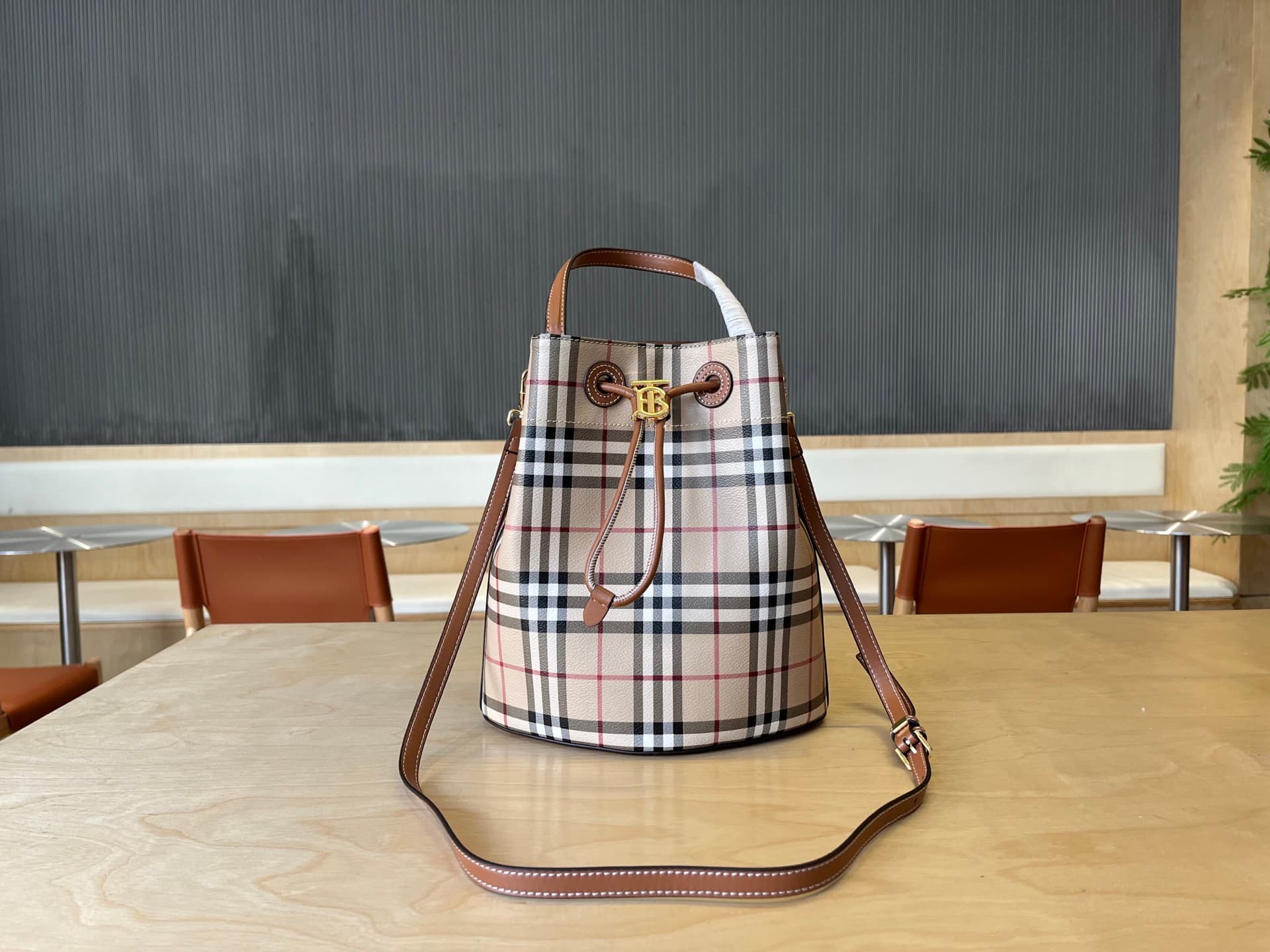 C14 B brand's latest bucket bag, crafted from large-sized patterned and ribbed leather material, adorned with the TB exclusive logo. This bag is a new member of the TB bag collection series, featuring a detachable and adjustable sling shoulder strap, and — image 1