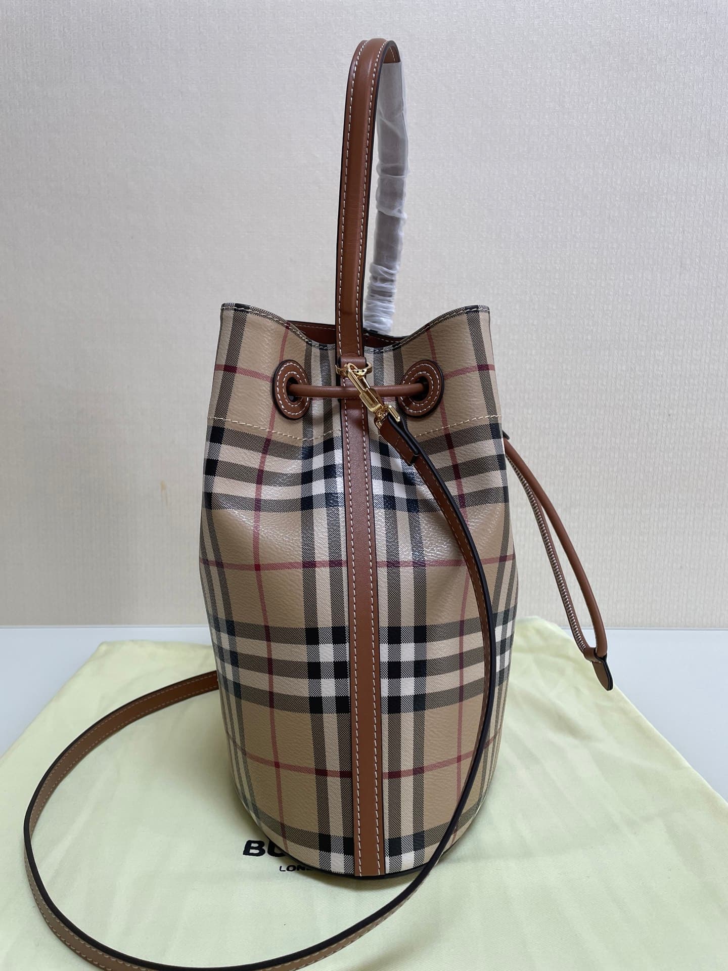 C12 B brand's latest bucket bag, crafted from large vintage/retro checked and glossy thread leather, adorned with the TB exclusive logo. This bag is a new member of the TB bag collection, featuring a detachable adjustable crossbody strap and an inner pock — image 4
