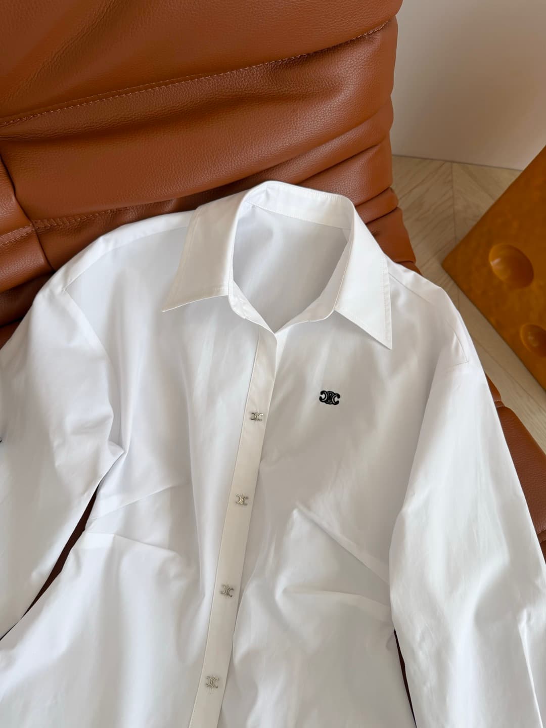 C18428 26 Spring/Summer – Triumph Arch logo embroidered design dress. A row of silver Triumph Arch buttons for decoration. An essential shirt dress for daily use; suitable for both work and vacation shopping. Shoulder-pull design, with a pleated waistline — image 3