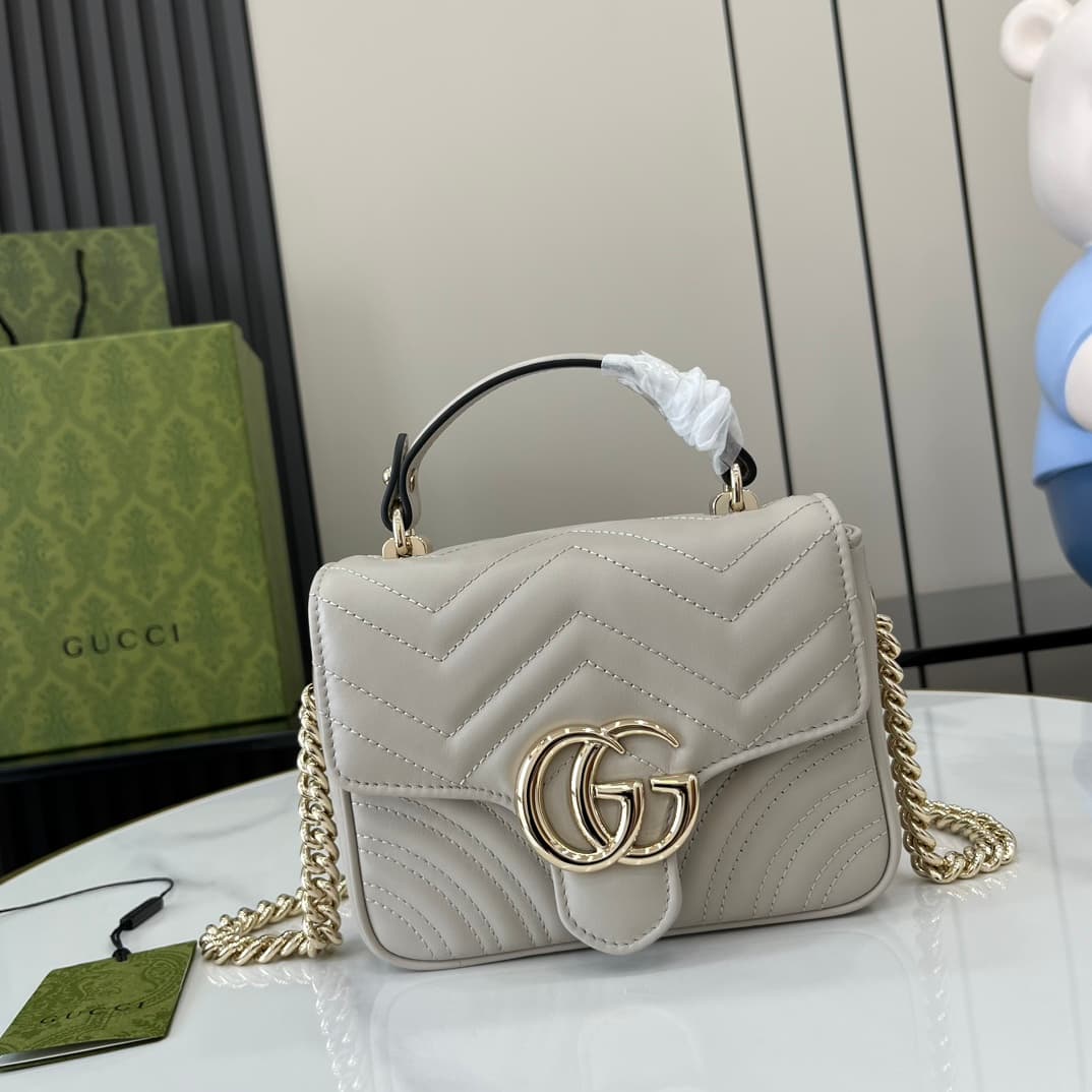C4021 GG Marmont collection mini handbag. The GG Marmont collection presents a new silhouette with classic colors, showcasing the charm of early autumn. This handbag is made of quilted V-shaped leather in Gucci Rosso Ancora light gray, with detachable buc — image 1