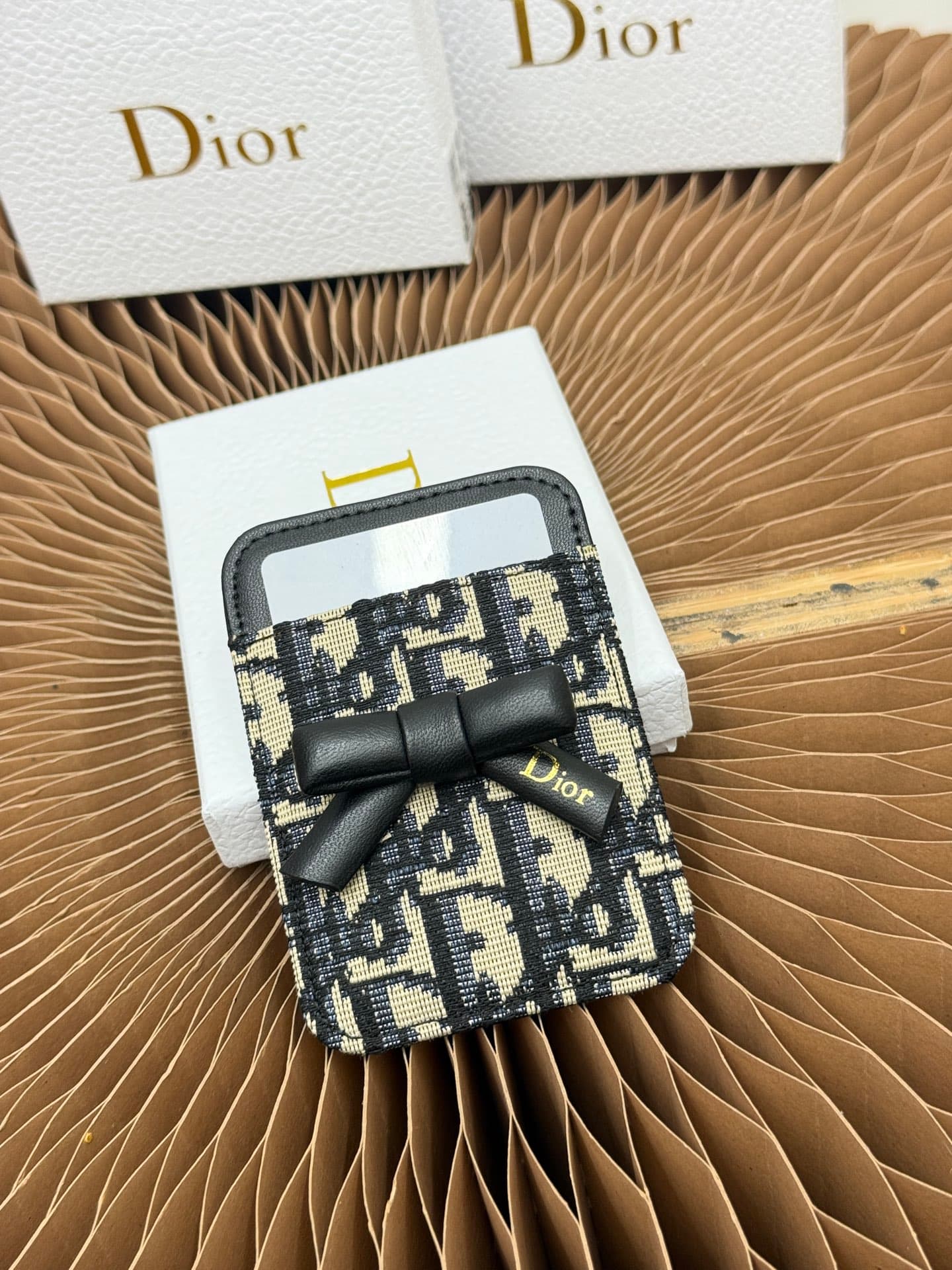 C390 This Lady Dior magnet card case is a delicate accessory that showcases the brand’s exquisite craftsmanship. The Cannage pattern in thread motif and the leather design are adorned with intricate bow ties – these are new elements of the Dior logo, high — image 1