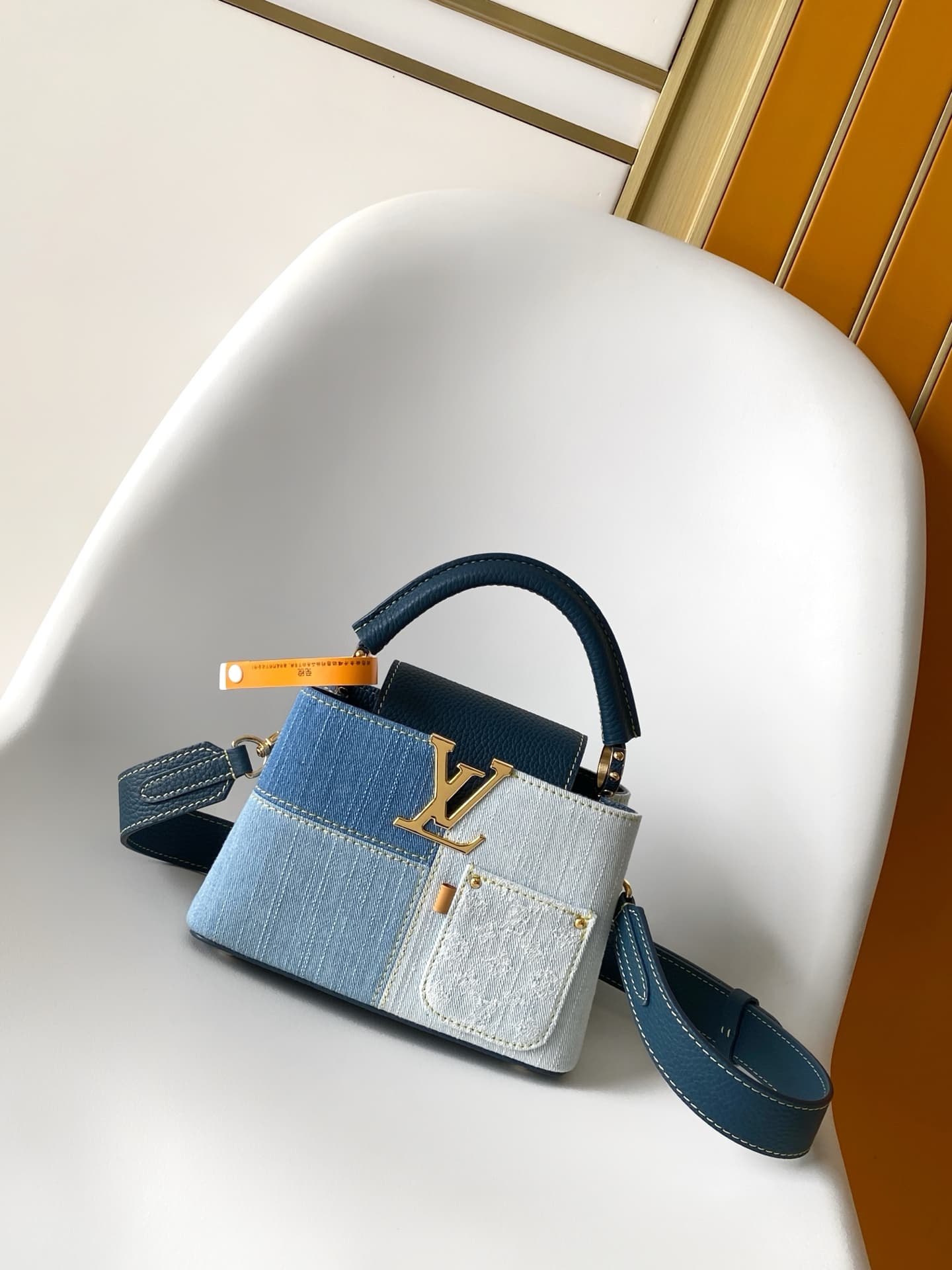 C5265 💰M27302 – Premium original style. The Capucines BB handbag features a denim material, reflecting contemporary fashion trends; its unique color-blocked design is distinctive. The bag comes with Taurillon leather handles, a flip cover, and a detachabl — image 1