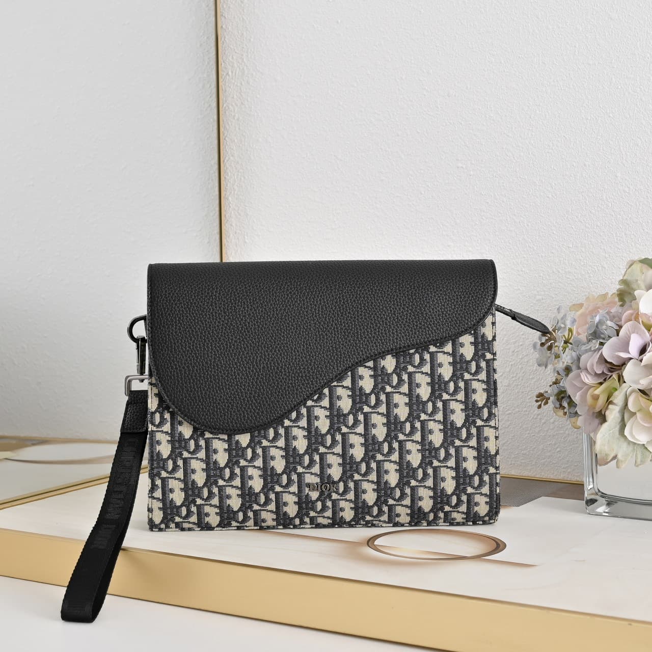 C1818 The A5 triangle-handbag is a new flagship product. It is crafted from beige and black Oblique-printed fabric, along with black suede leather with a saddle-shaped flap design. The spacious zipper compartment can hold a phone, and there are also card — image 1