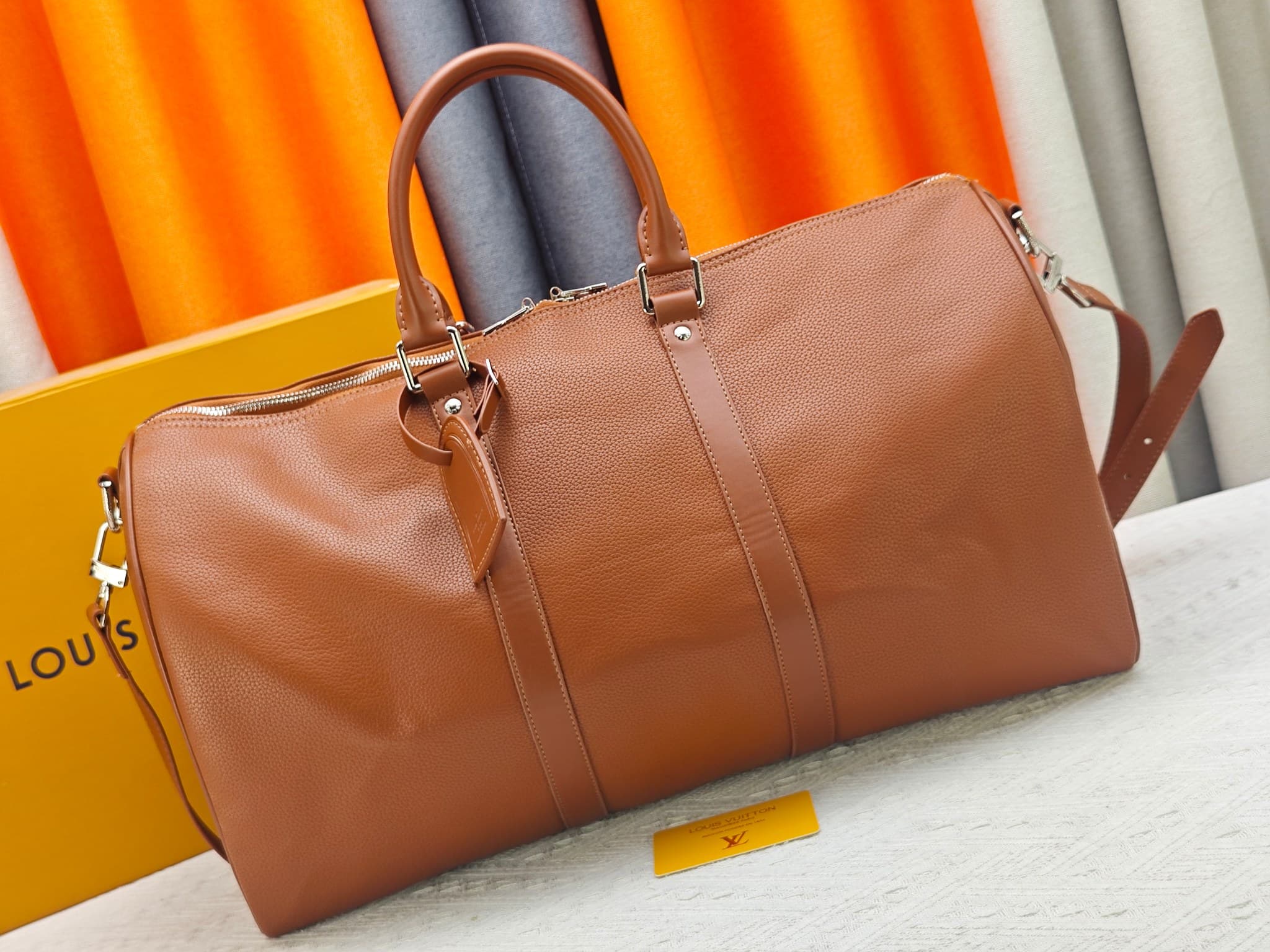 C5291 M41416 M26065 Brown. This Keepall Bandouliere 50 travel bag is made from polished cowhide leather and fabric lining, making it an excellent choice for weekend trips. The fine, soft leather and the LV logo exude elegance; the handle at the top and th — image 1