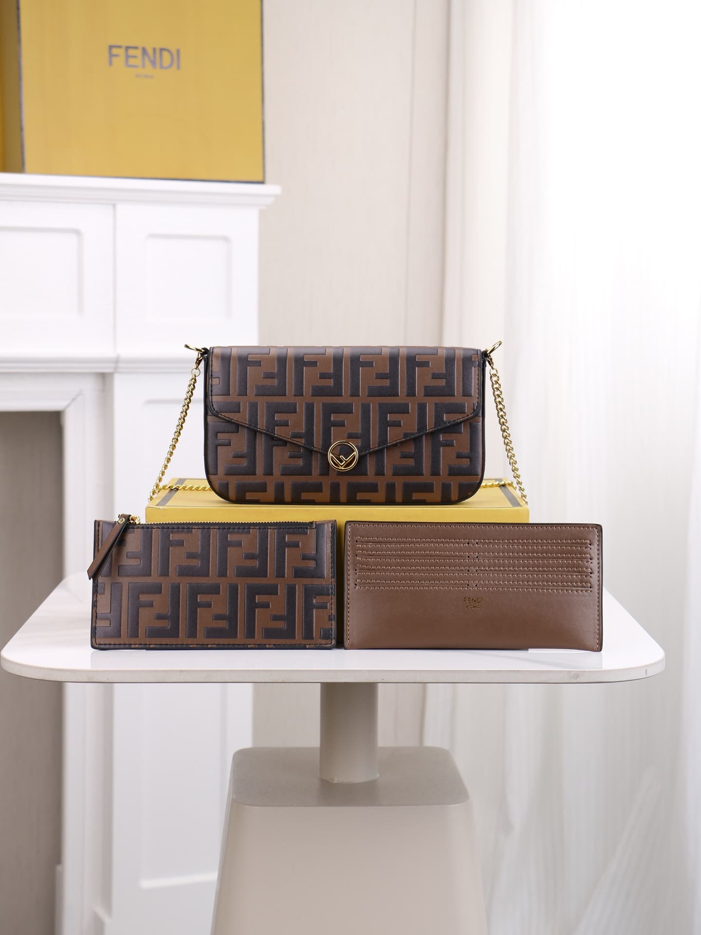 C2870 Fendi mini handbag with geometric patterns, featuring a flap closure and zipper opening. It has a detachable chain strap. The interior is equipped with flat pockets. The bag’s exterior is made of distinctive brown leather with black raised FF prints — image 1
