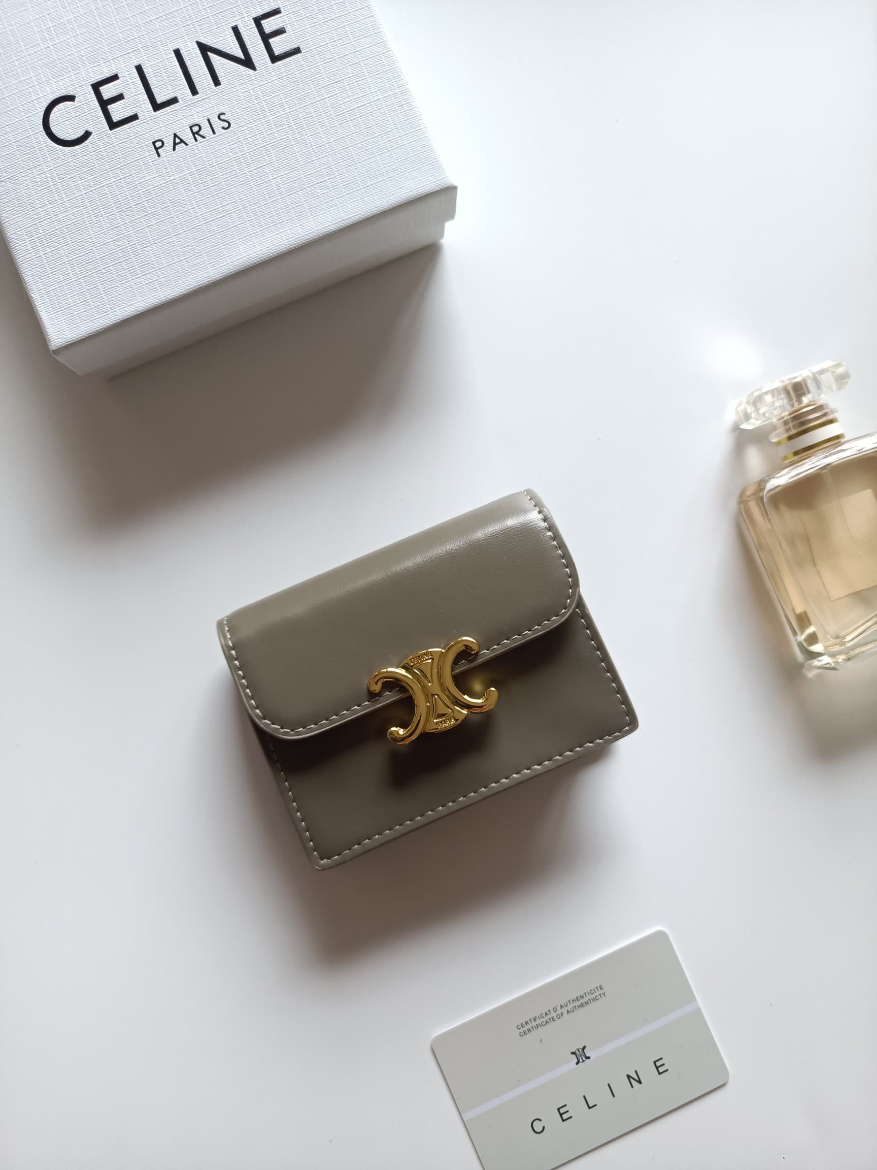 C462 Celine’s new card holder – TRIOMPHE name card case. It features a classic pattern on the large surface area, with flat-stitched microfiber material. The exterior is covered with golden trim. The case uses TRIOMPHE metal zippers for opening and closin — image 1