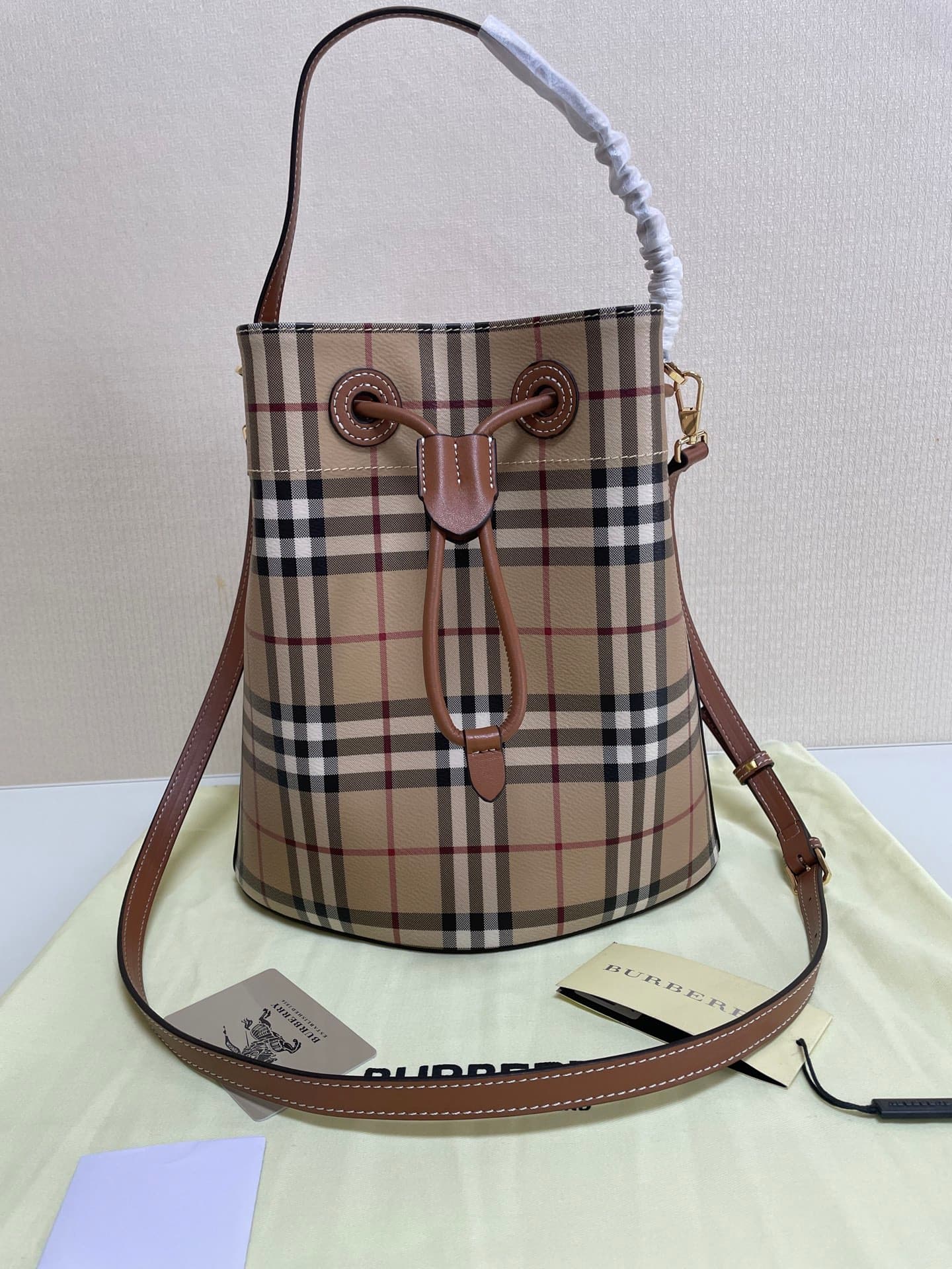 C12 B brand's latest bucket bag, crafted from large vintage/retro checked and glossy thread leather, adorned with the TB exclusive logo. This bag is a new member of the TB bag collection, featuring a detachable adjustable crossbody strap and an inner pock — image 1