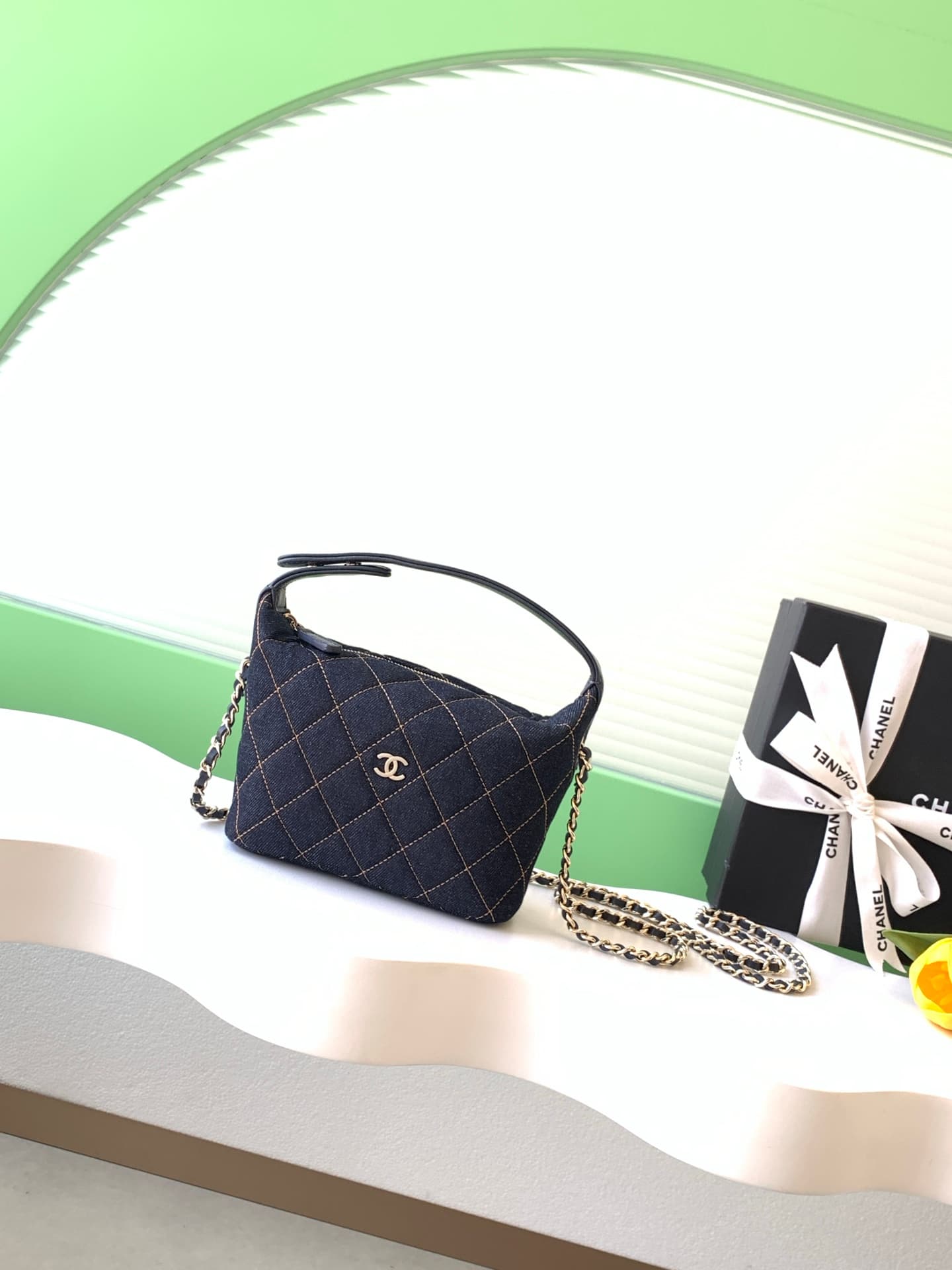 C725 26P Denim lunchbox bag: dark denim fabric with classic diamond pattern design; metal chains and leather straps. It can be carried in hand, over shoulder, or crossbody style. The bag is small and cute in size; it has enough space for a phone, keys, an — image 1