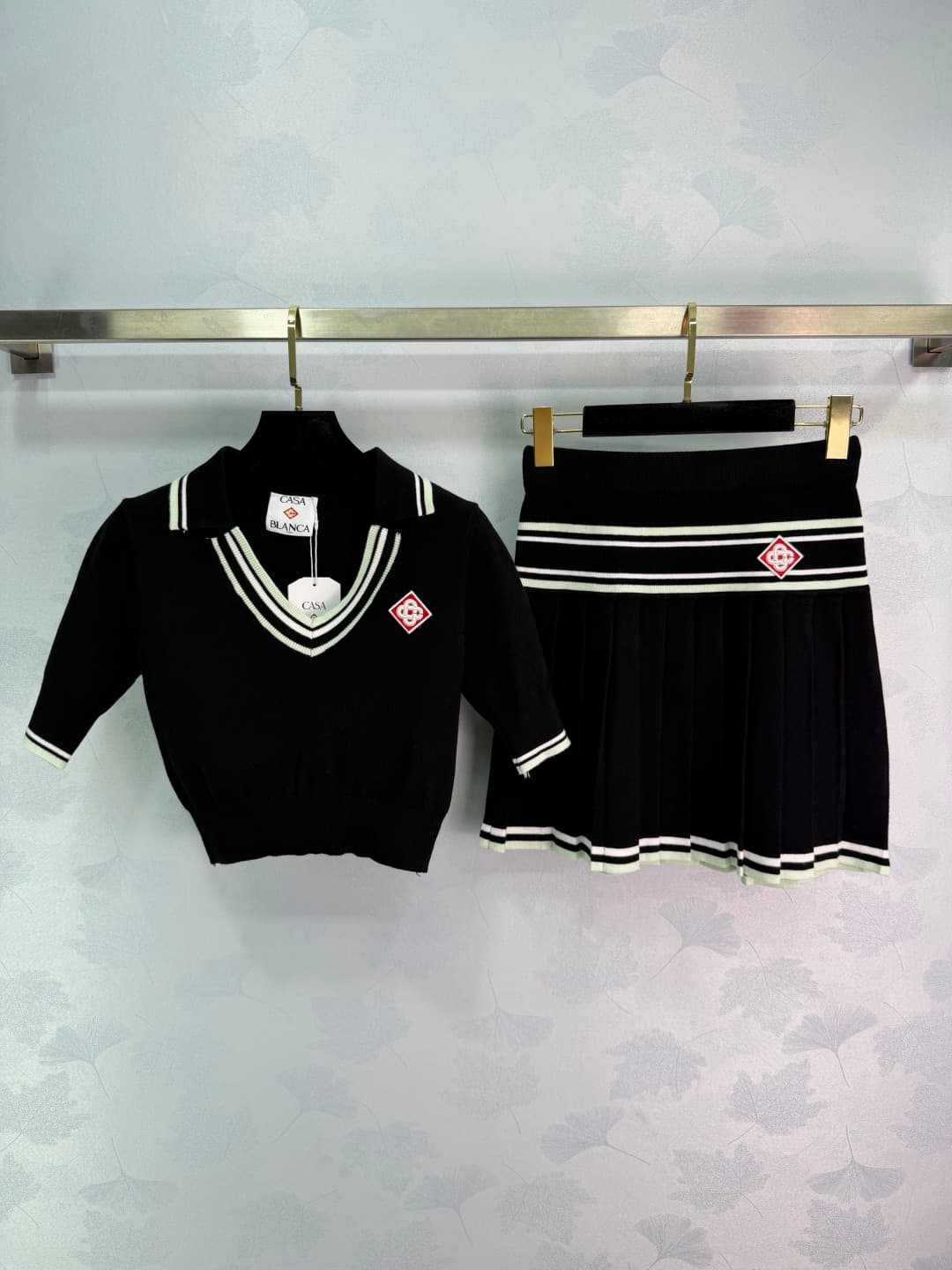 C18448 🆕CA*26 – New spring/summer school-style outfit: short knit top + pleated skirt. Black with white stripes. Simple yet energetic design. The top has a V-neck, with brand embroidery on the chest; short sleeves provide better ventilation. The skirt has — image 1